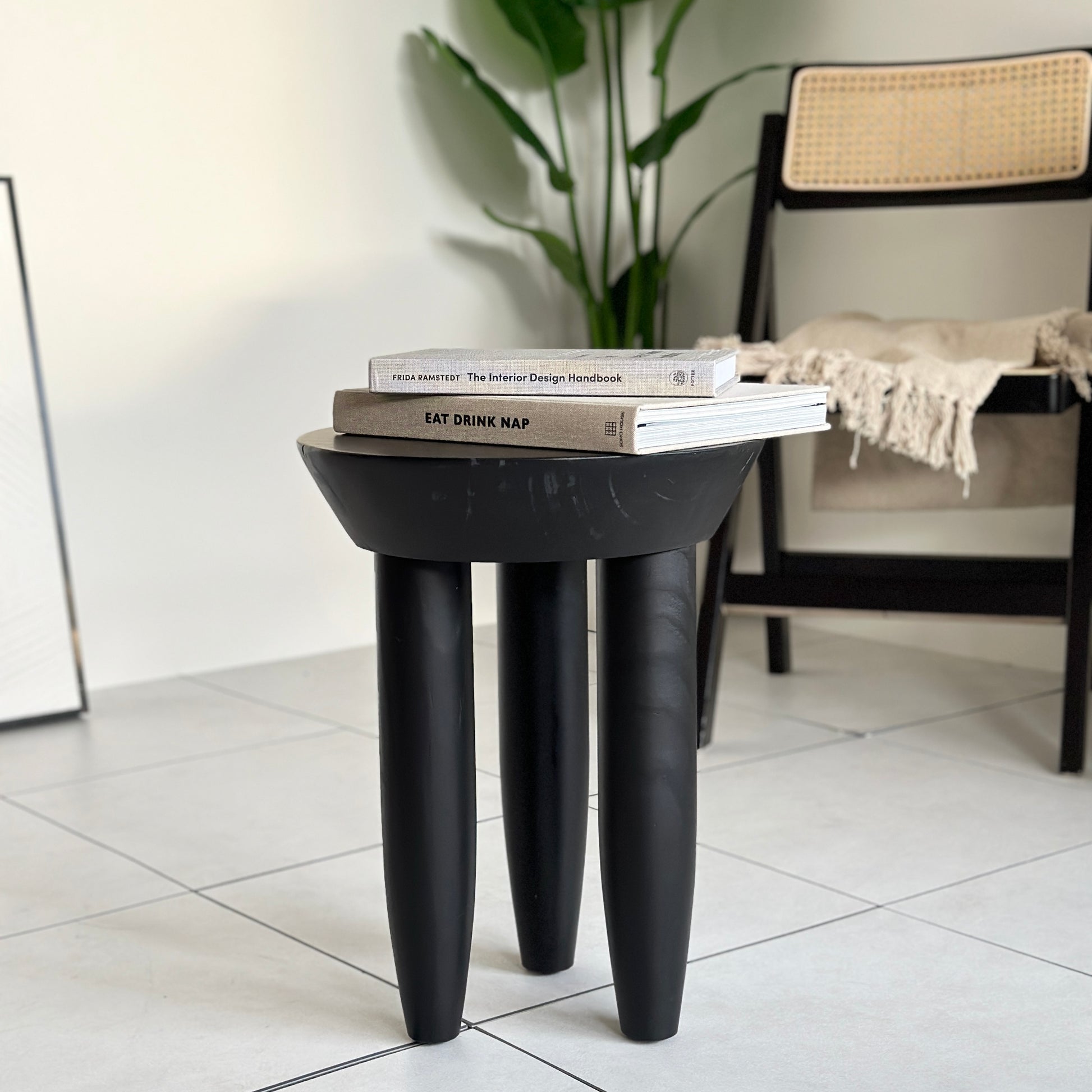 本が2冊乗っているブラックの木製スツール