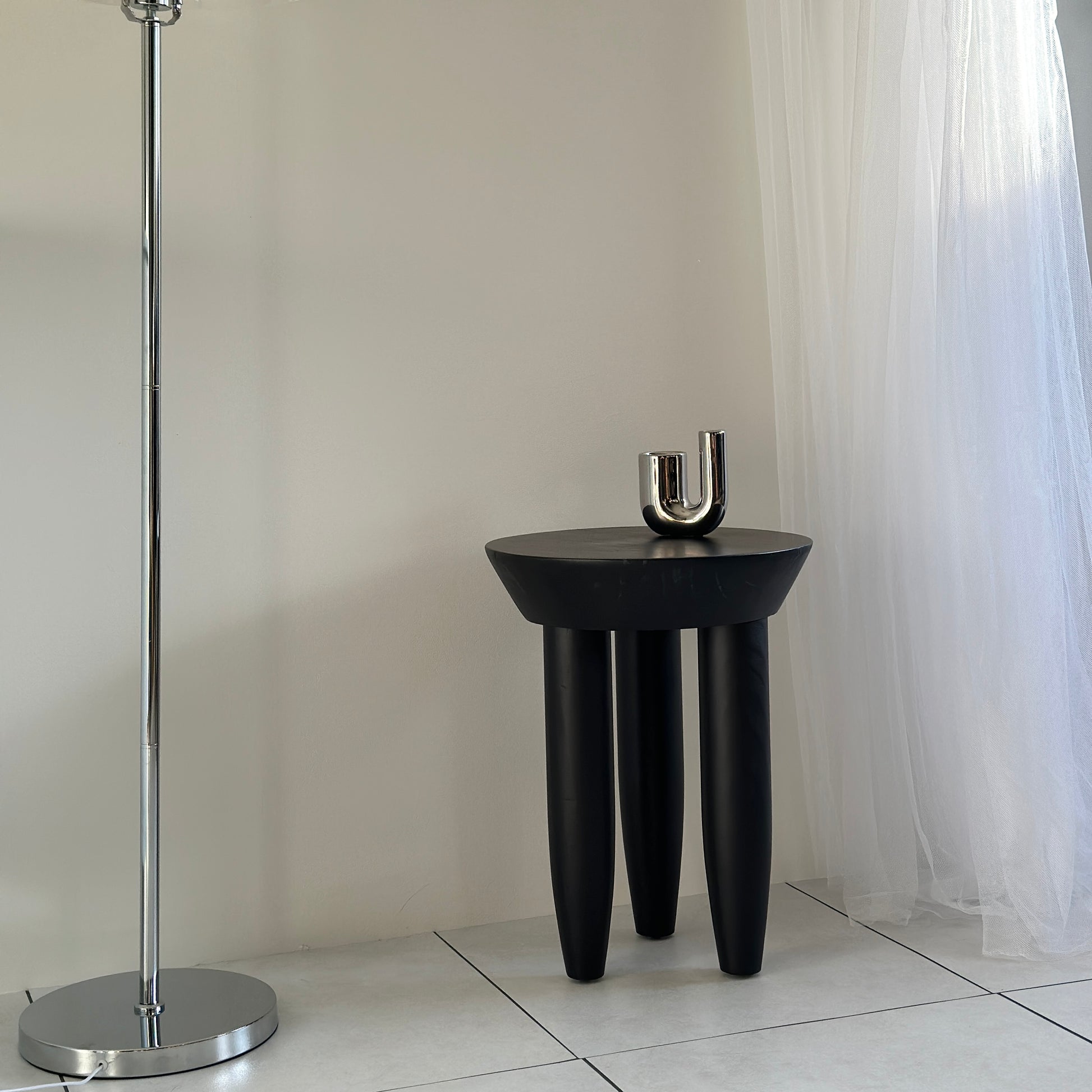 キャンドルホルダーが乗っているブラックの木製スツール