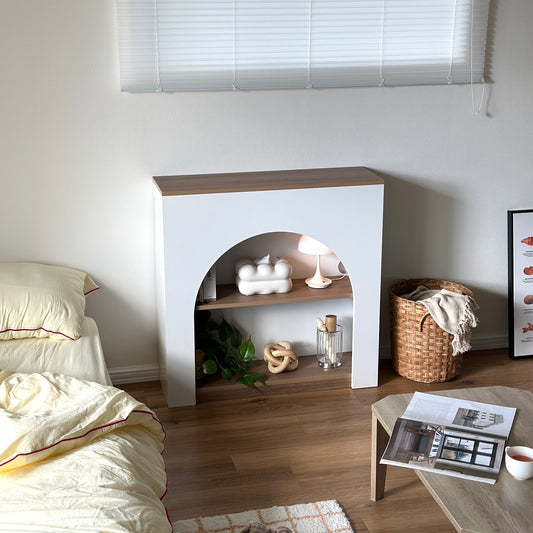 ホワイトのアーチ型デザインのマントルピースを部屋に置いている様子