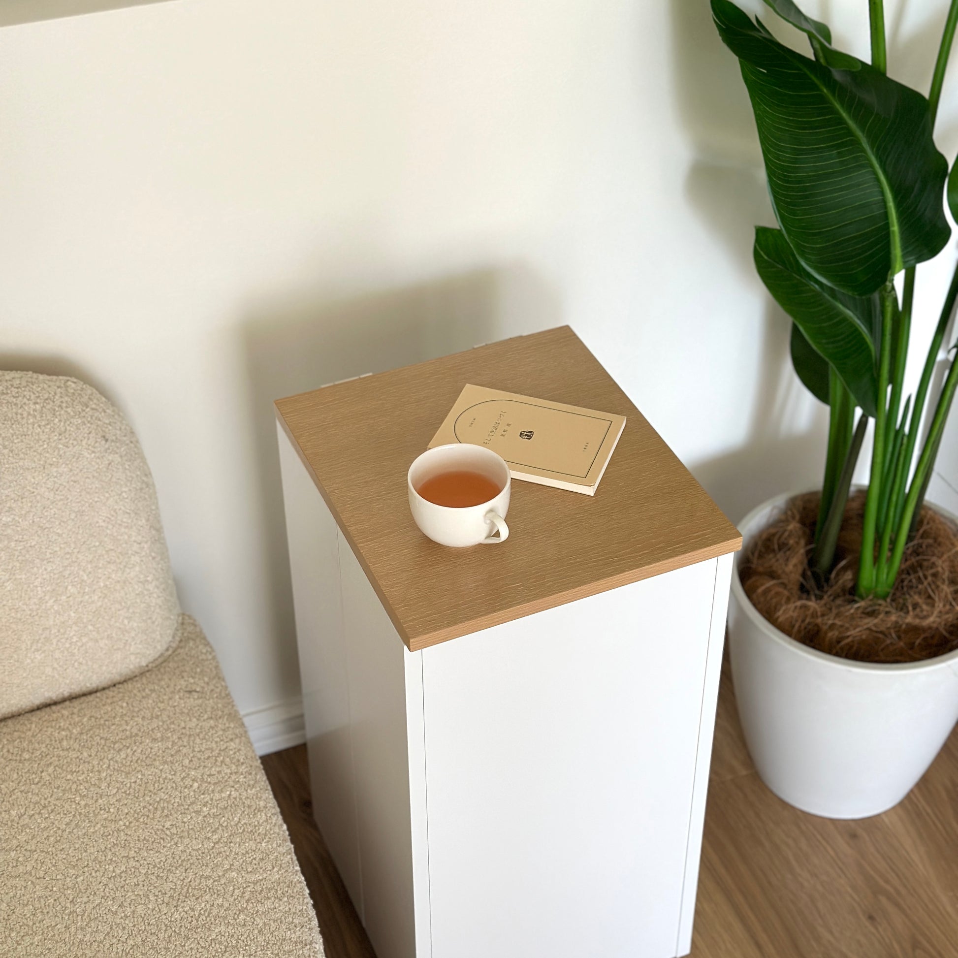 ホワイトのキャスター付きスリムワゴンの上に文庫本とコップを置いている様子