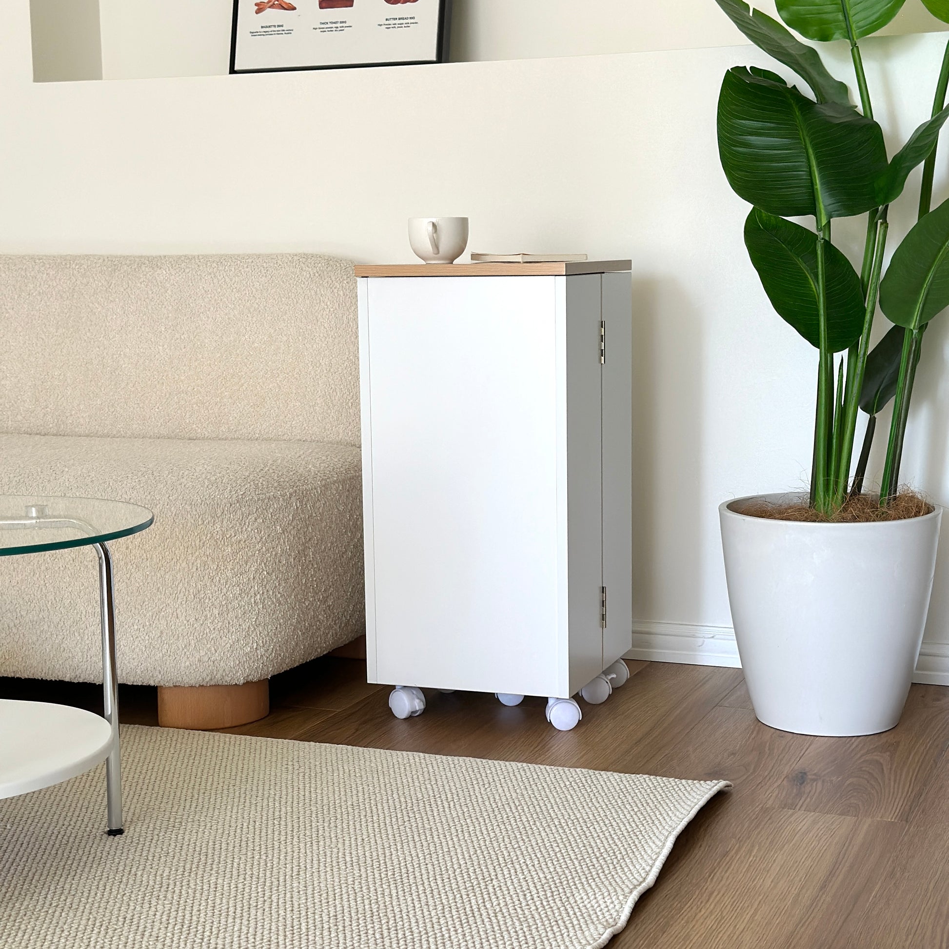 ホワイトのキャスター付きコスメワゴンをソファーサイドに置いている様子