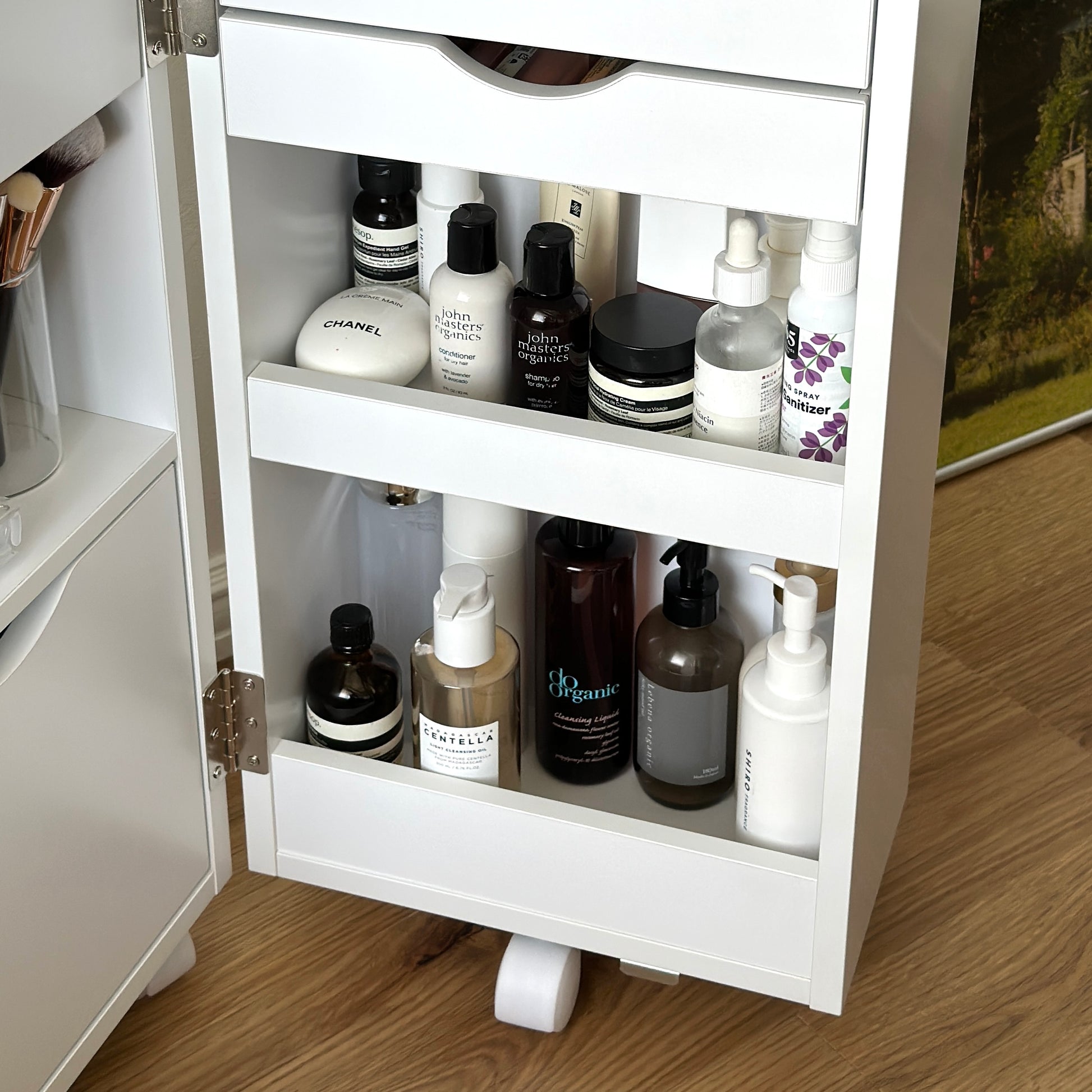 ホワイトのキャスター付きコスメワゴンにスキンケア用品を収納している様子