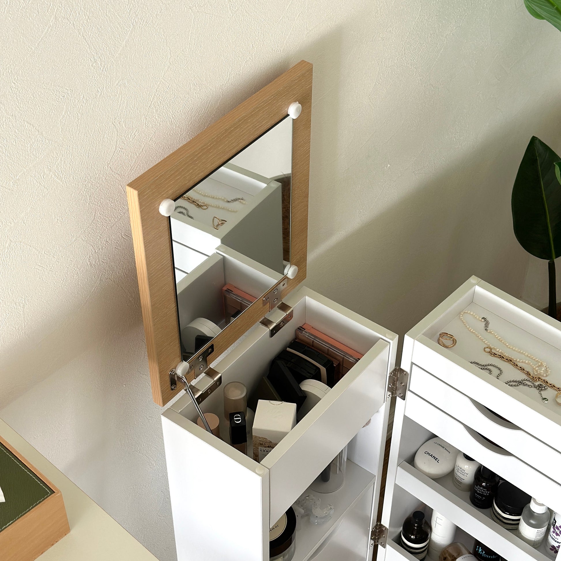 ホワイトのキャスター付きコスメワゴンの中にスキンケア用品やメイク道具を収納している様子