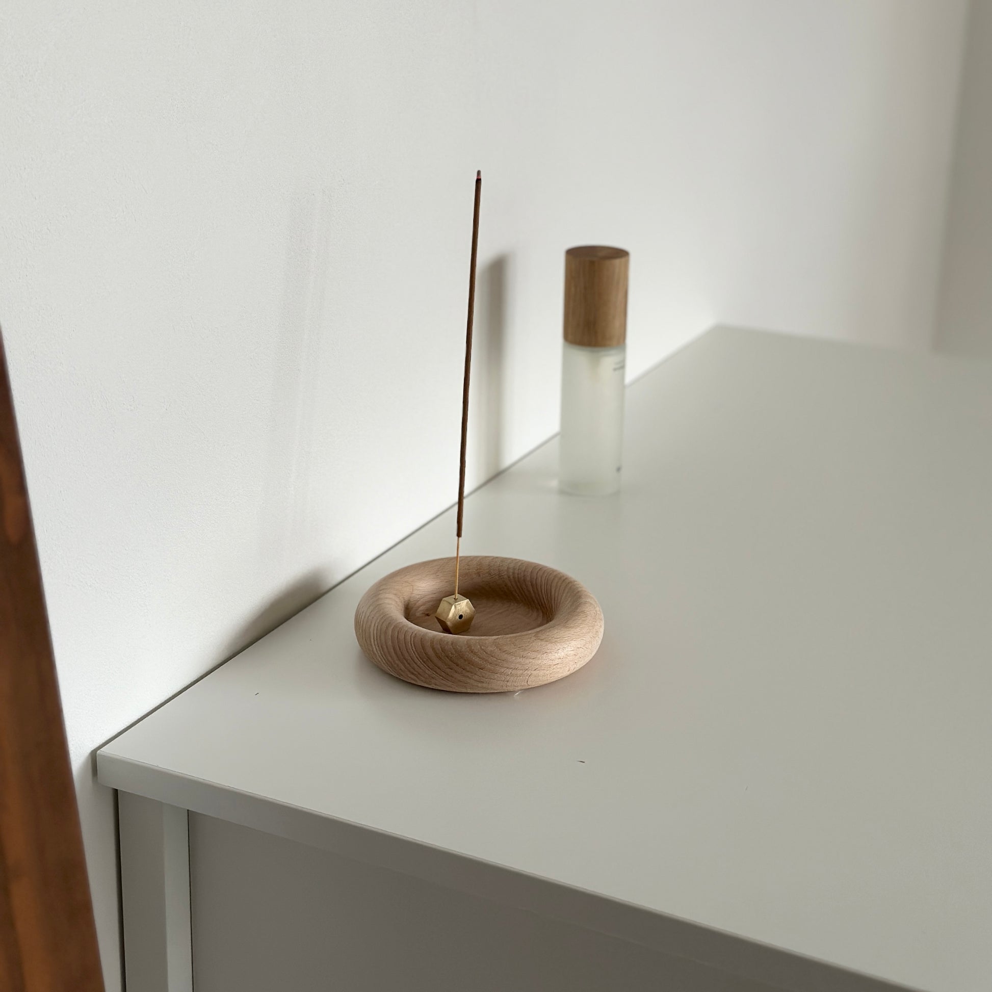 フチがぽってりした木製プレートにお香が置かれている