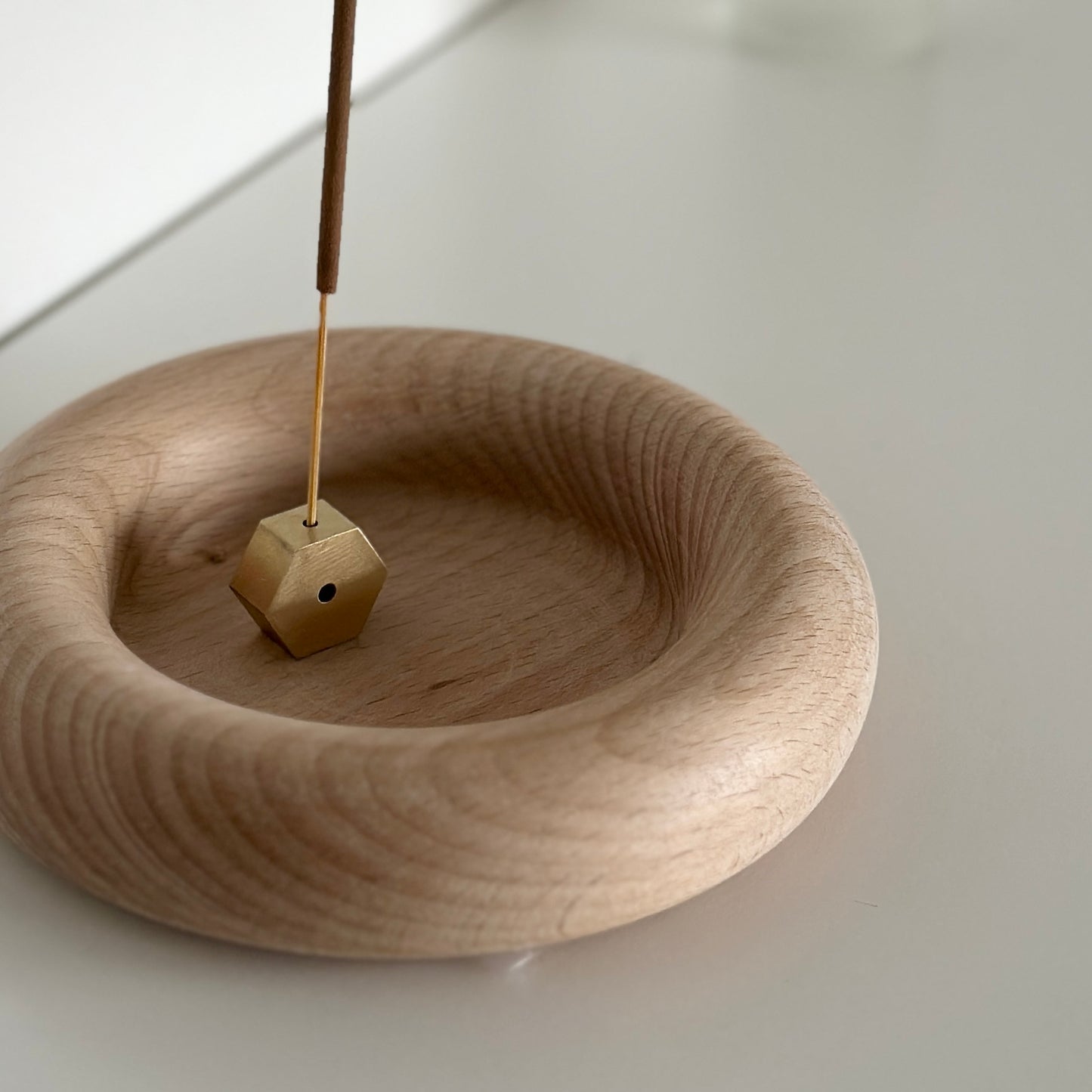 フチがぽってりした木製プレートにお香が置かれている