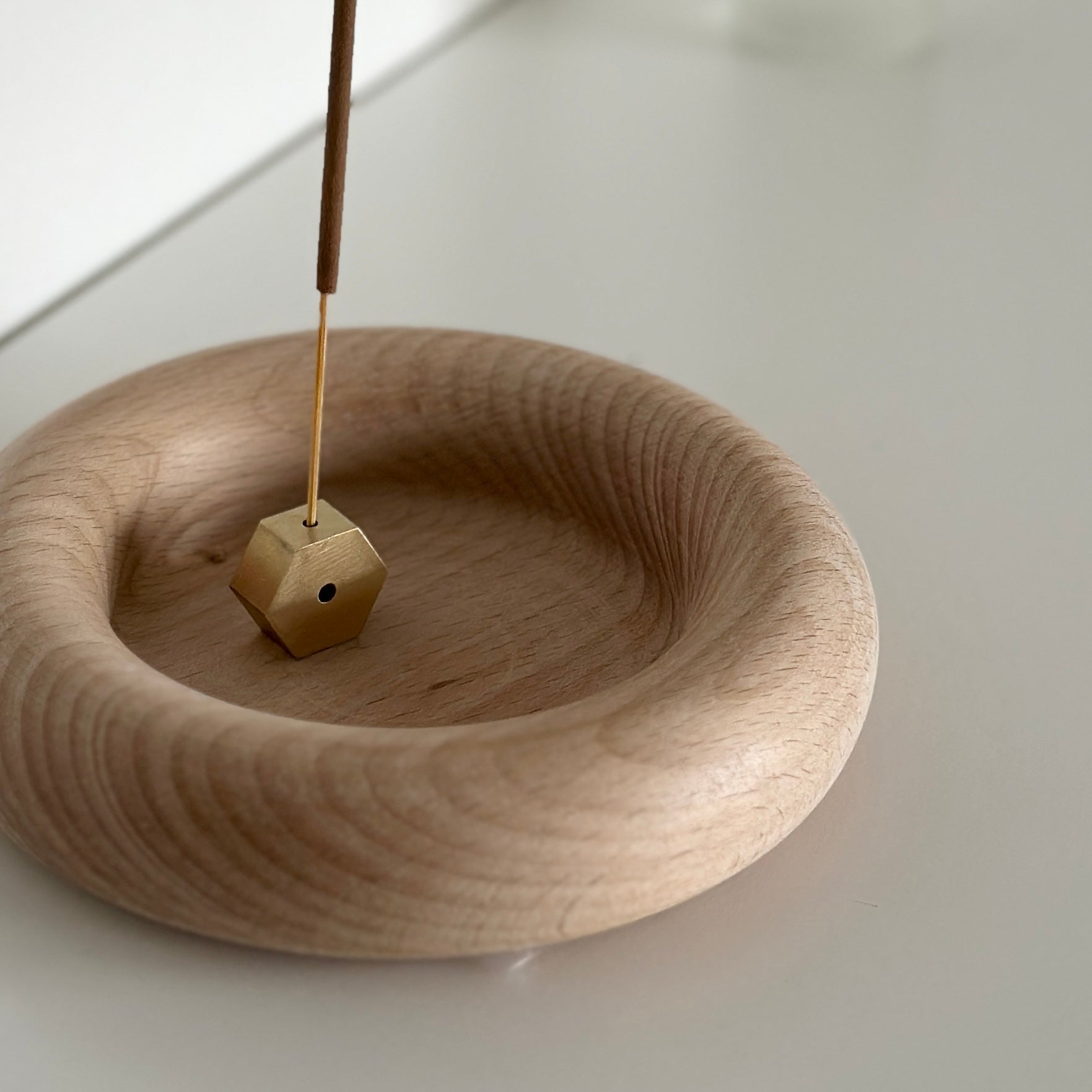 フチがぽってりした木製プレートにお香が置かれている