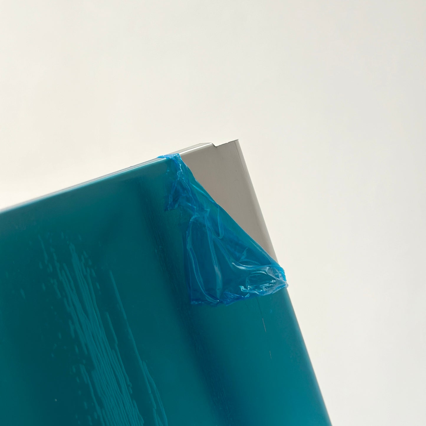 ステンレスの3段のシェルフの保護シールを剥がしている様子