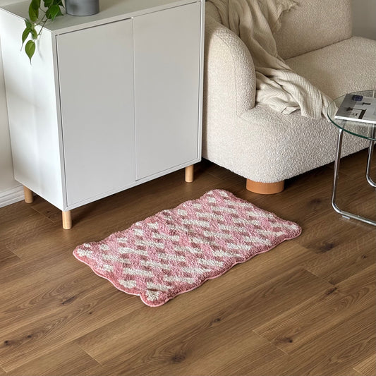 ピンクのウェーブクロス柄のミニラグを白棚の前に敷いている様子
