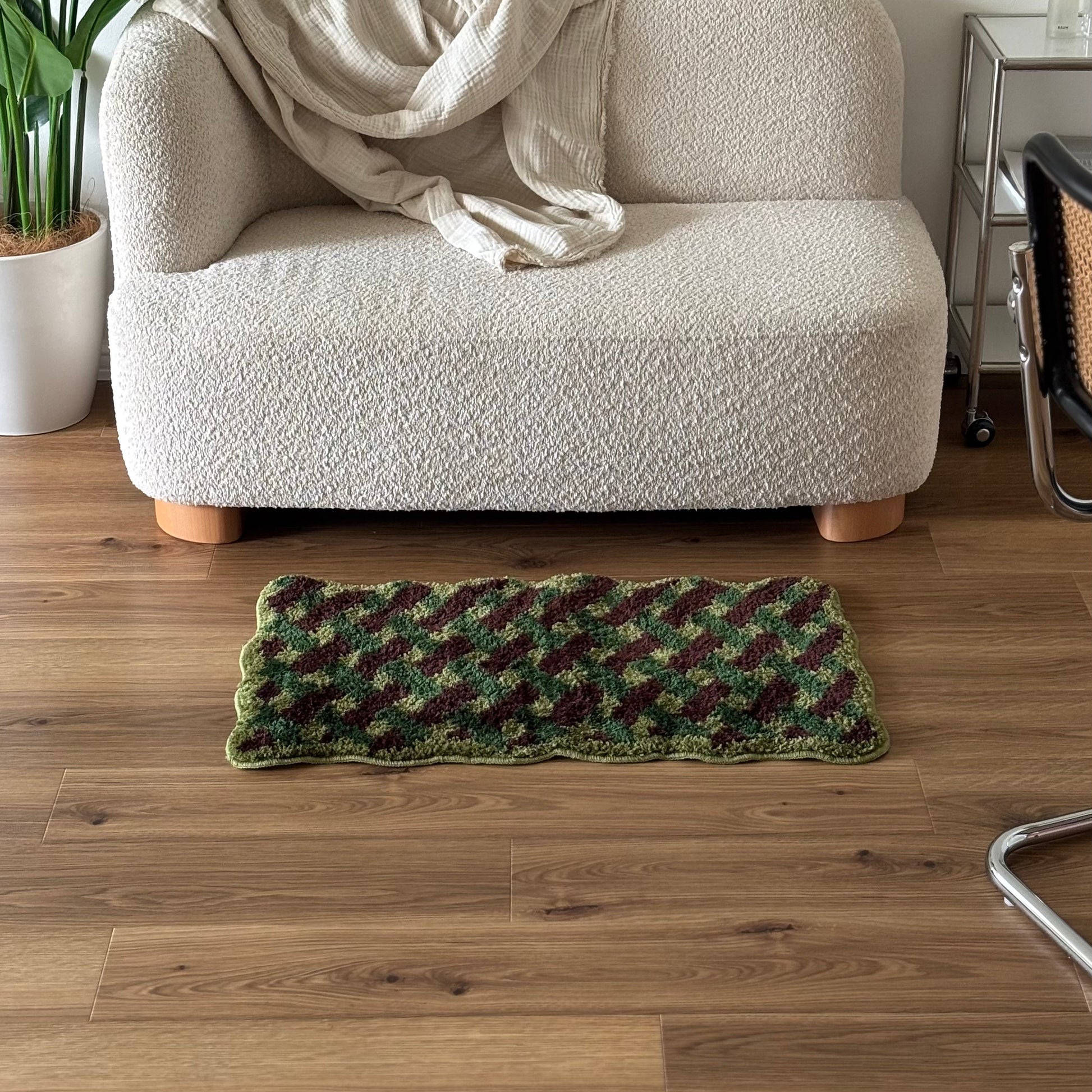 グリーンのウェーブクロス柄のミニラグをソファ前に敷いている様子