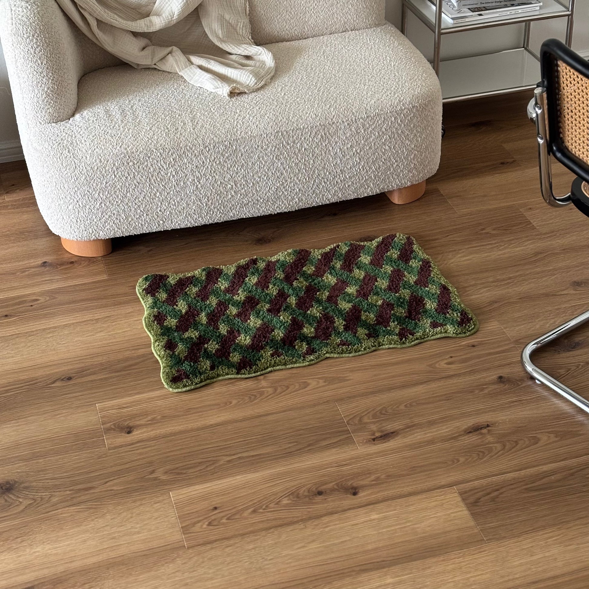 グリーンのウェーブクロス柄のミニラグをソファ前に敷いている様子
