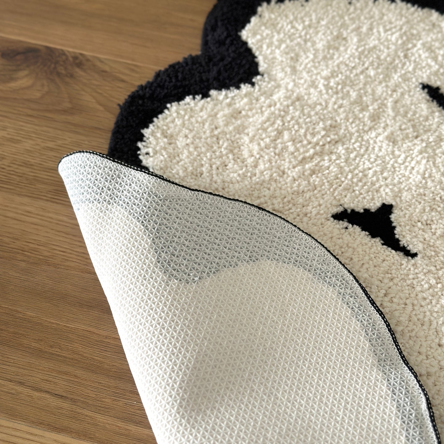 モノトーンのクラウドラグの裏側をめくっている様子