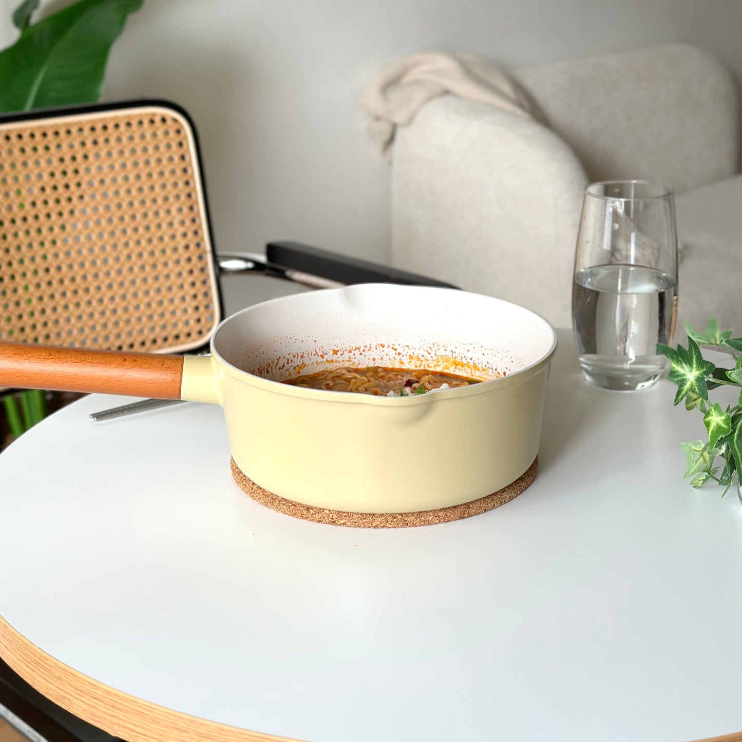 ラーメンが入った黄色の片手鍋がダイニングテーブルの上に置かれている様子