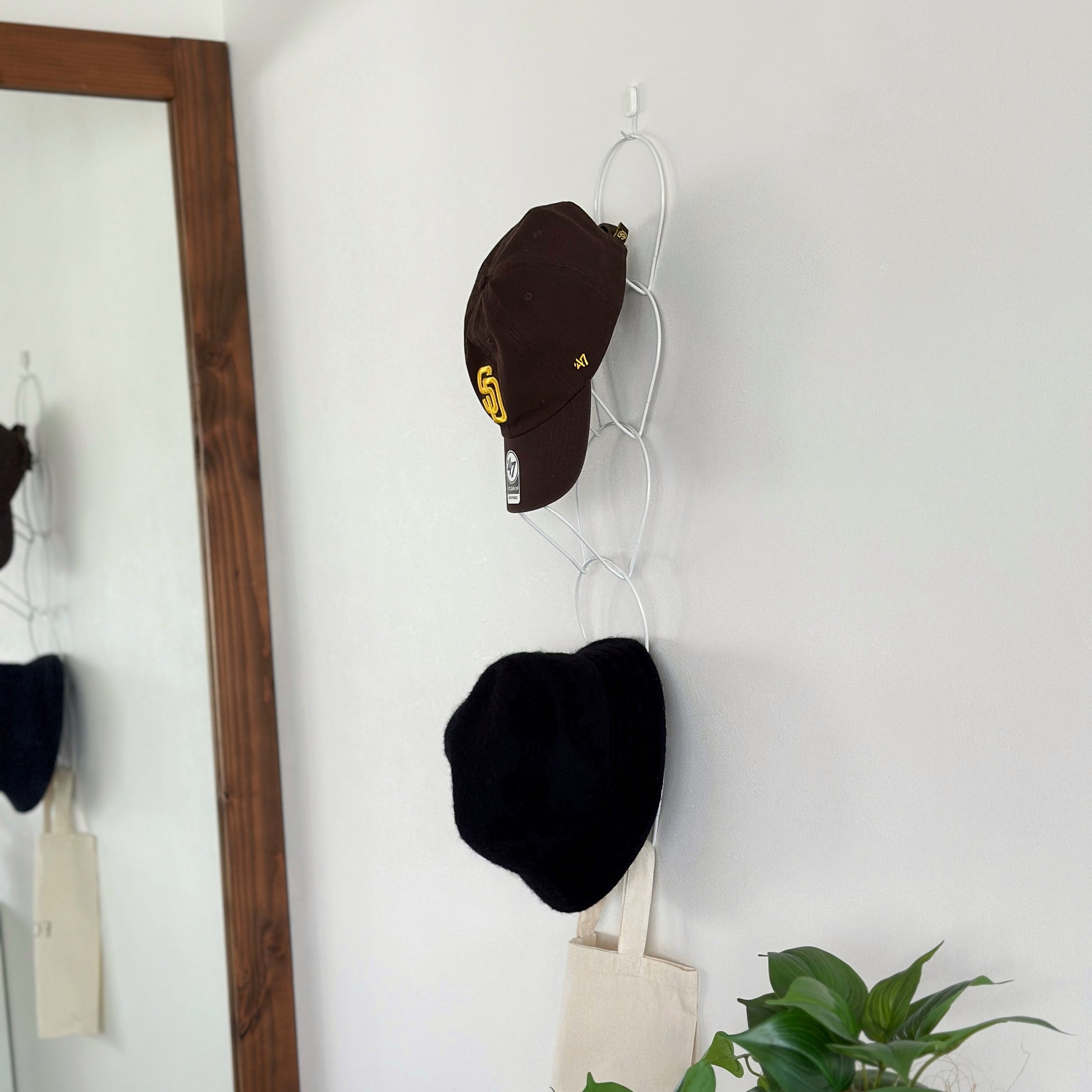 ホワイトの帽子掛けハンガーに帽子が2つ掛かっている様子