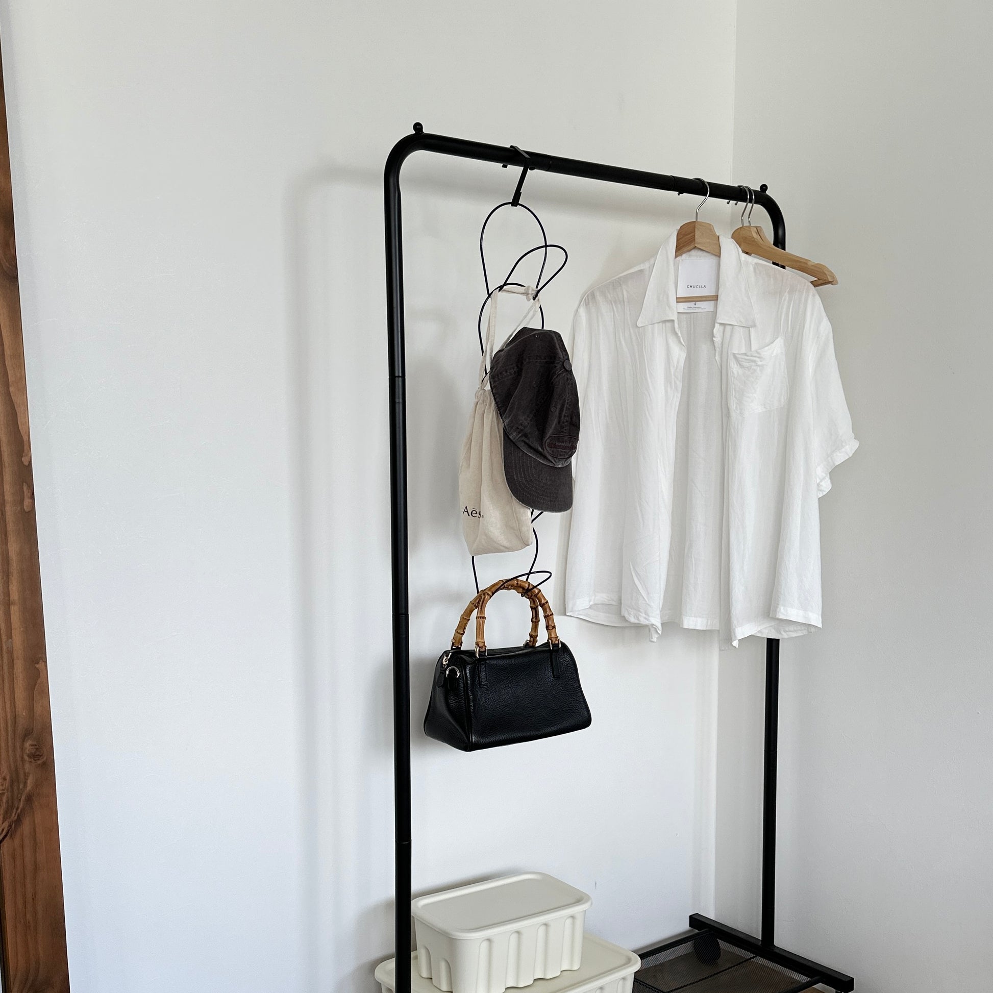 ブラックの帽子掛けハンガーが黒のハンガーラックに掛かっている