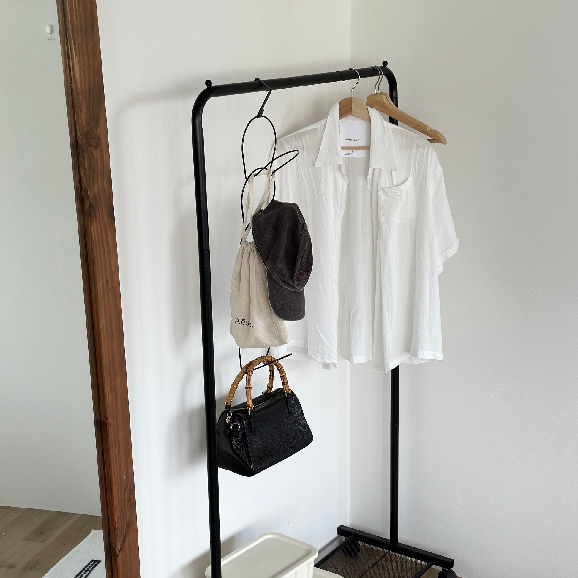 ブラックの帽子掛けハンガーが黒のハンガーラックに掛かっている