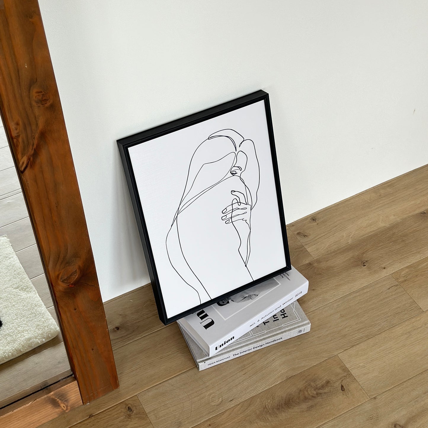 女性が振り向いた姿が描かれたラインアートが2冊の本の上に置かれている