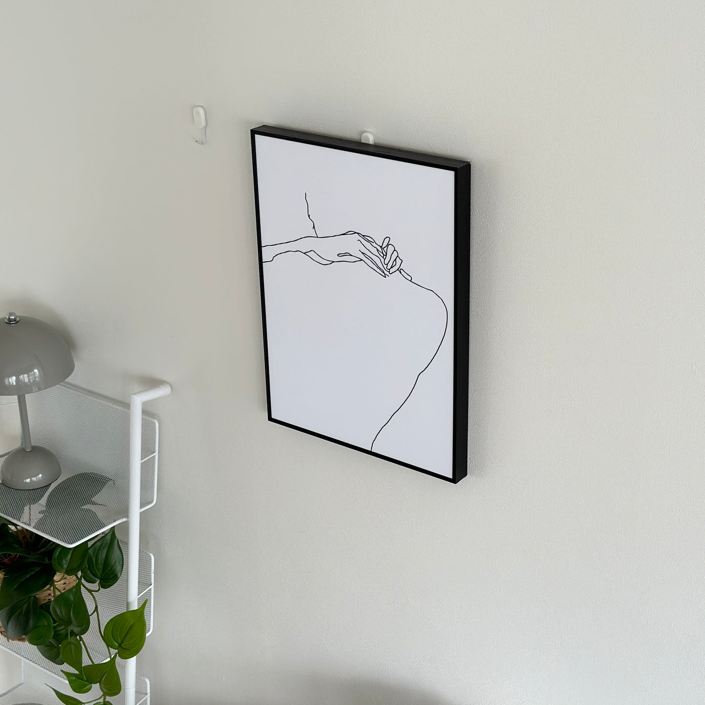 ニュアンスライン後ろ姿が描かれたアートが壁にかけられている