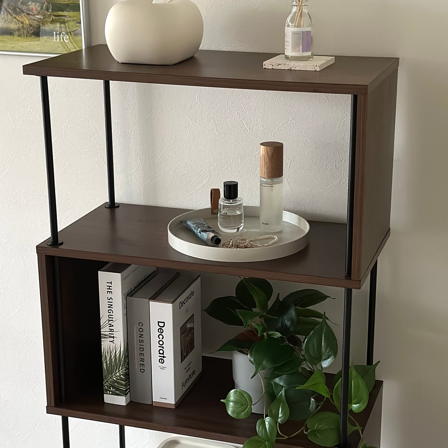 フェイクレザーのラウンド型のトレイに香水やハンドクリーム、アクセサリーを置いている様子