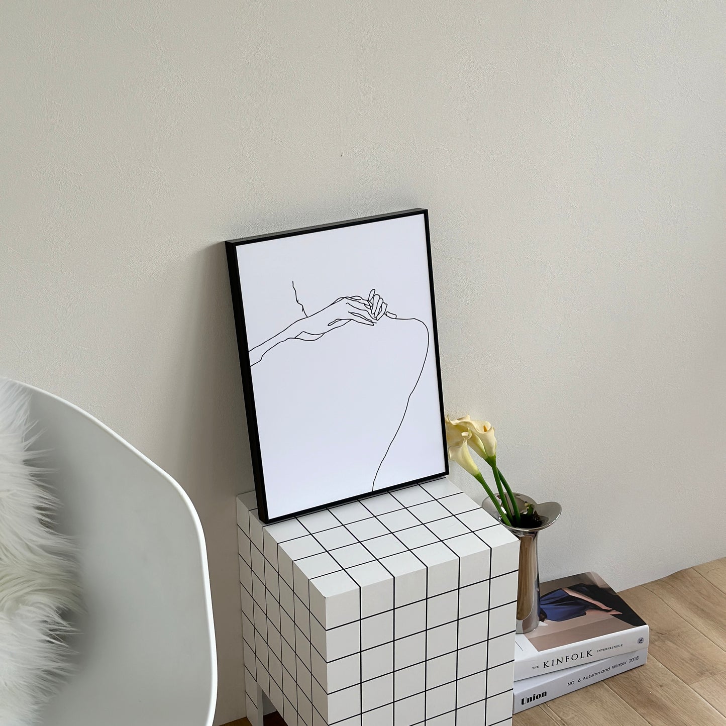 ニュアンスライン後ろ姿が描かれたアートがスツールの上に置かれている