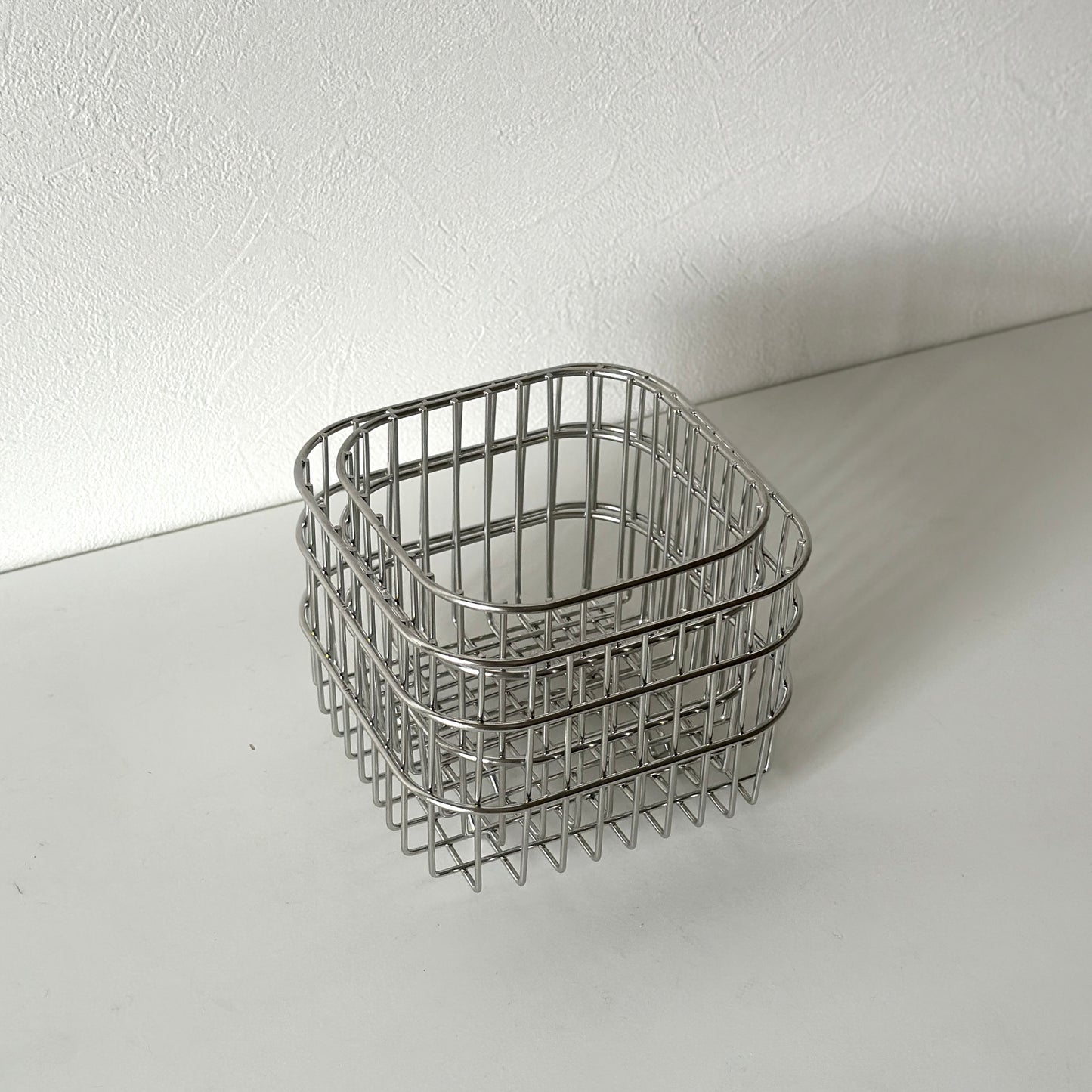 大きさの違うシルバーのスクエア型のバスケットがスタッキングされている様子