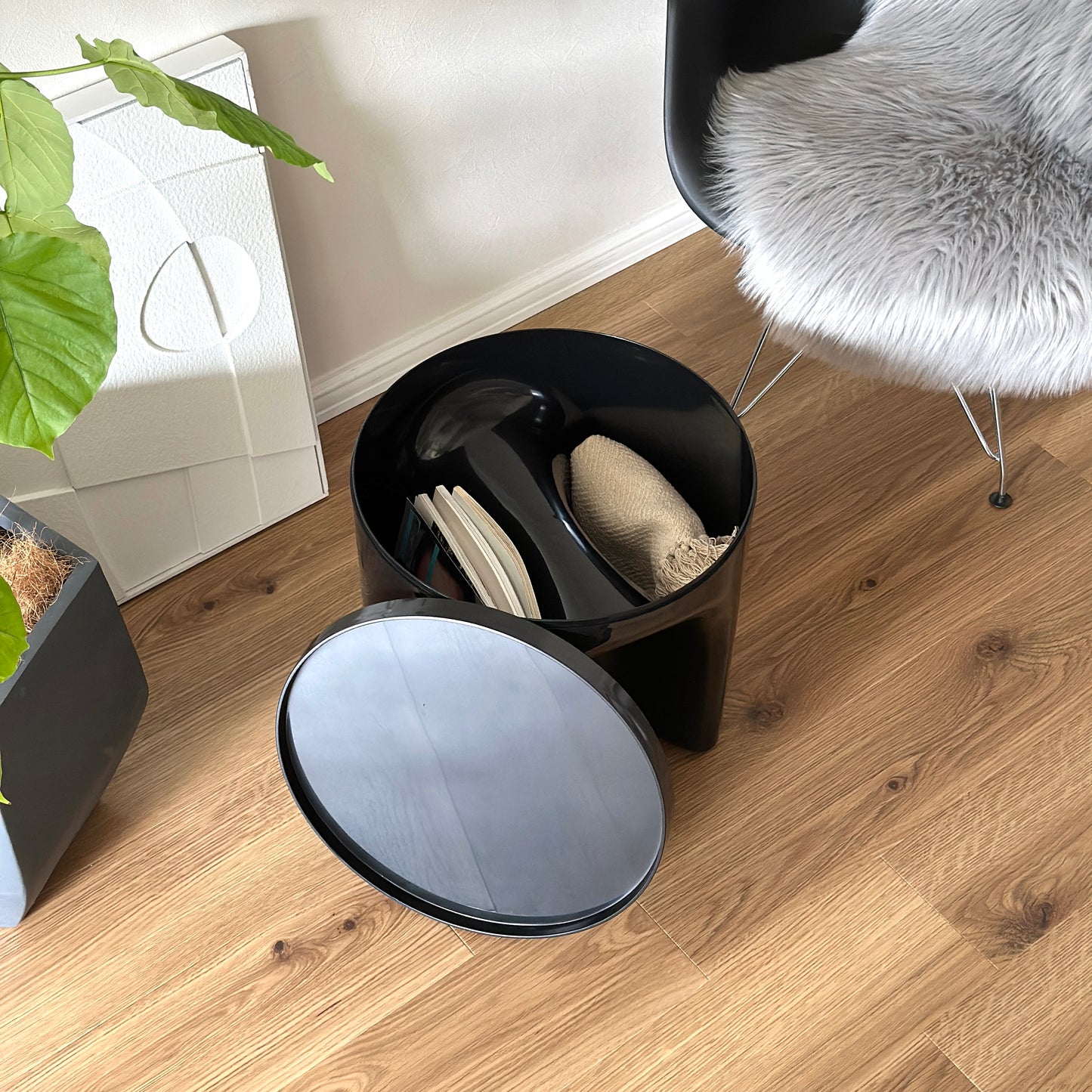 オブジェのようなサイドテーブルの中に雑誌やブランケットを収納している様子