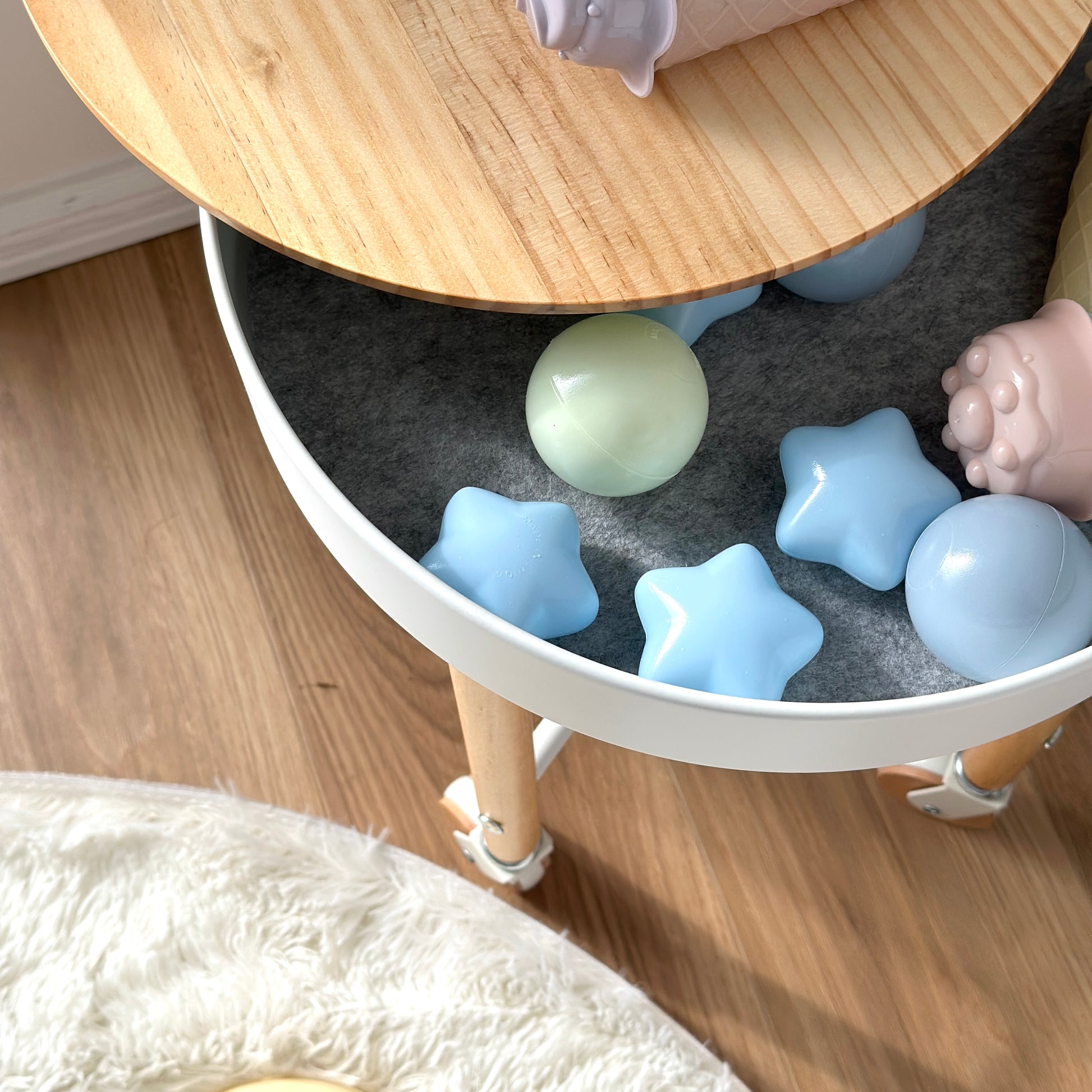 キャスター付きの収納ができるサイドテーブルの収納におもちゃを入れている様子