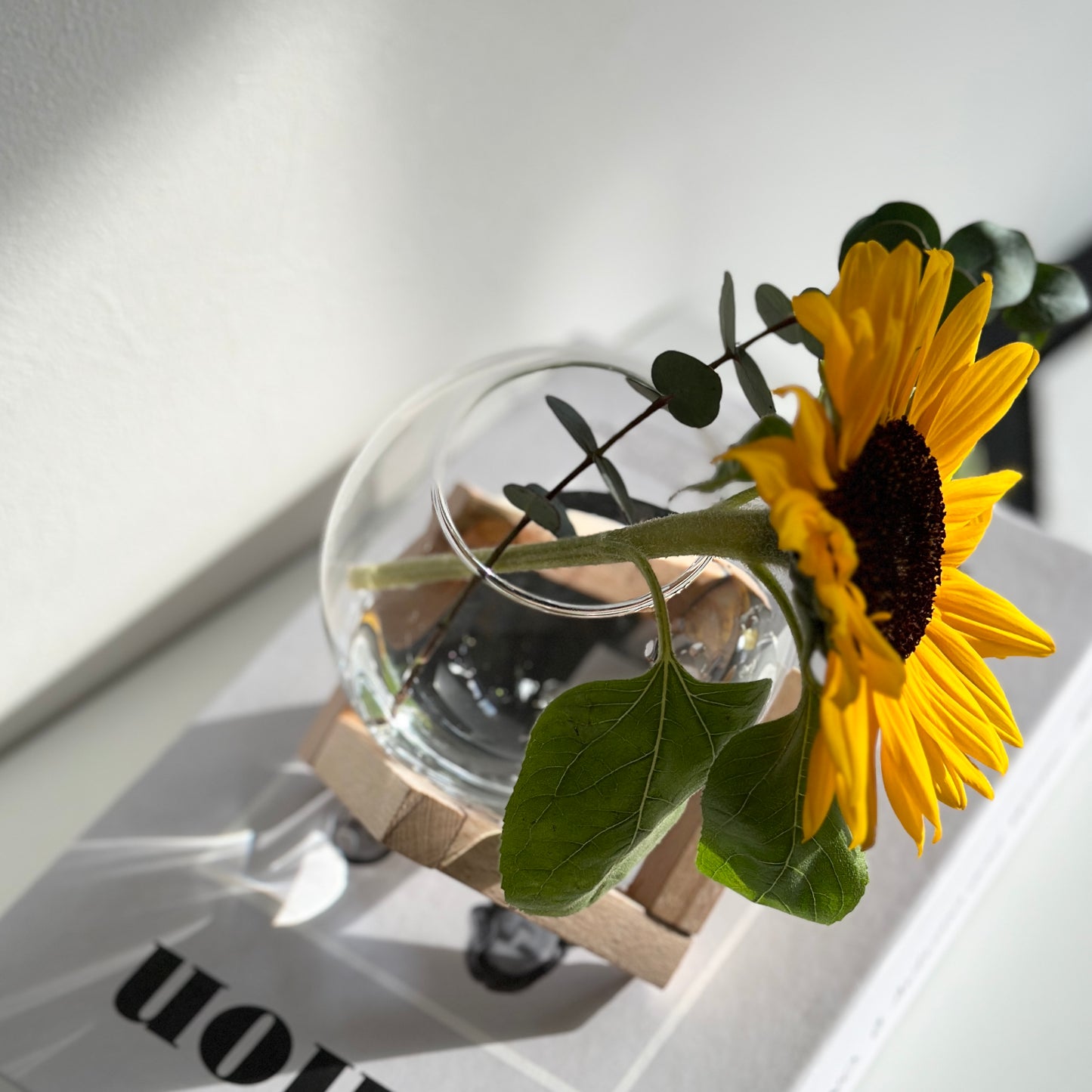 木製のスタンドとガラスの組み合わせのフラワーベースに花を飾っている様子