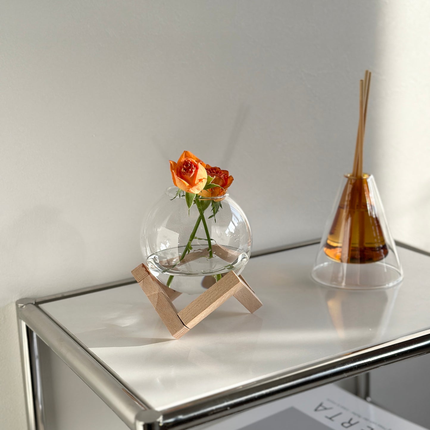 木製のスタンドとガラスの組み合わせのフラワーベースに花を飾っている様子