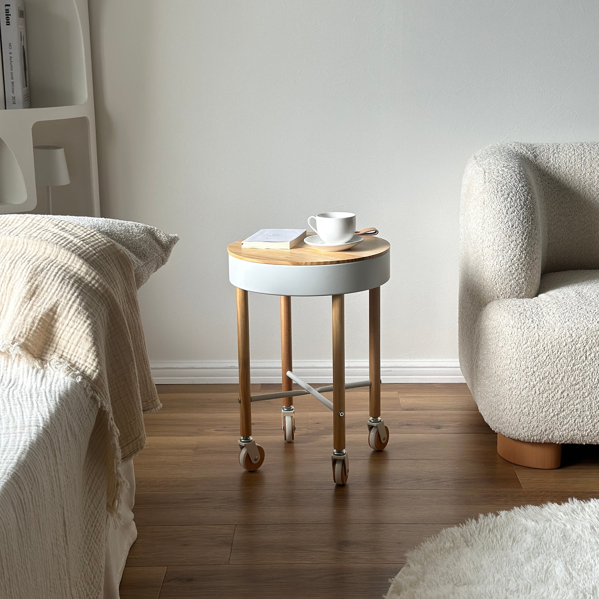 キャスター付きの収納ができるサイドテーブルがベッド横に置かれている様子