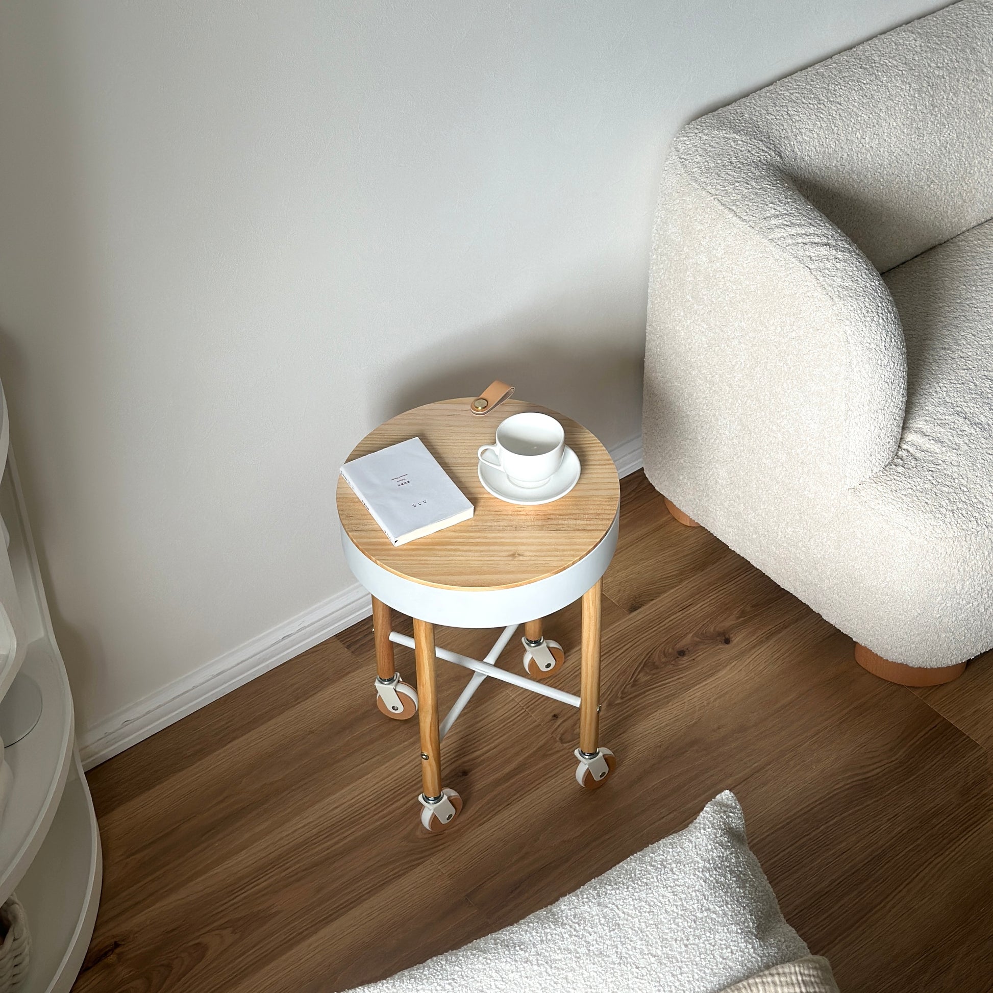 キャスター付きの収納ができるサイドテーブルの上に本やカップが置かれている様子
