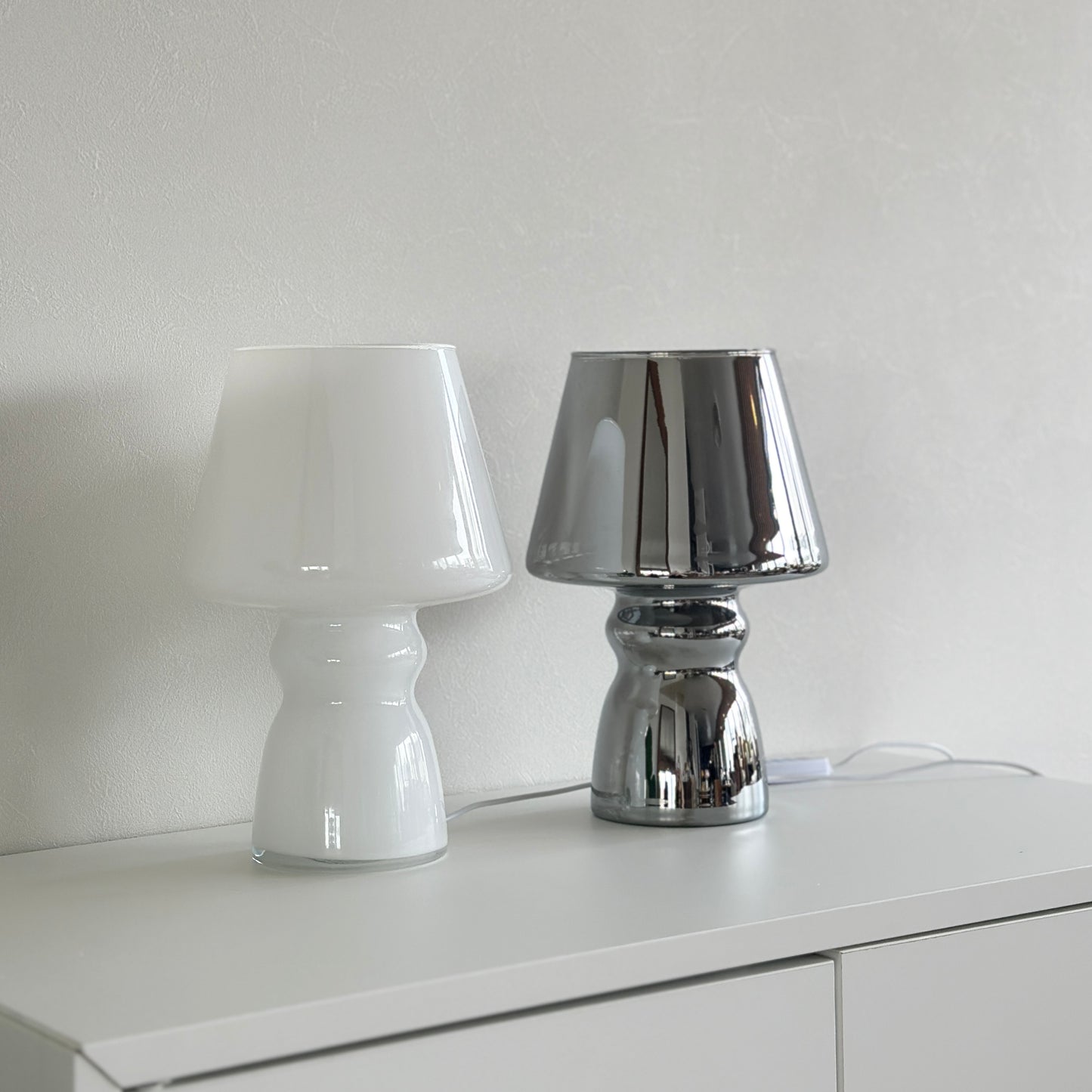 ホワイトとシルバーのアンティークを感じるライトが棚の上に置かれている様子