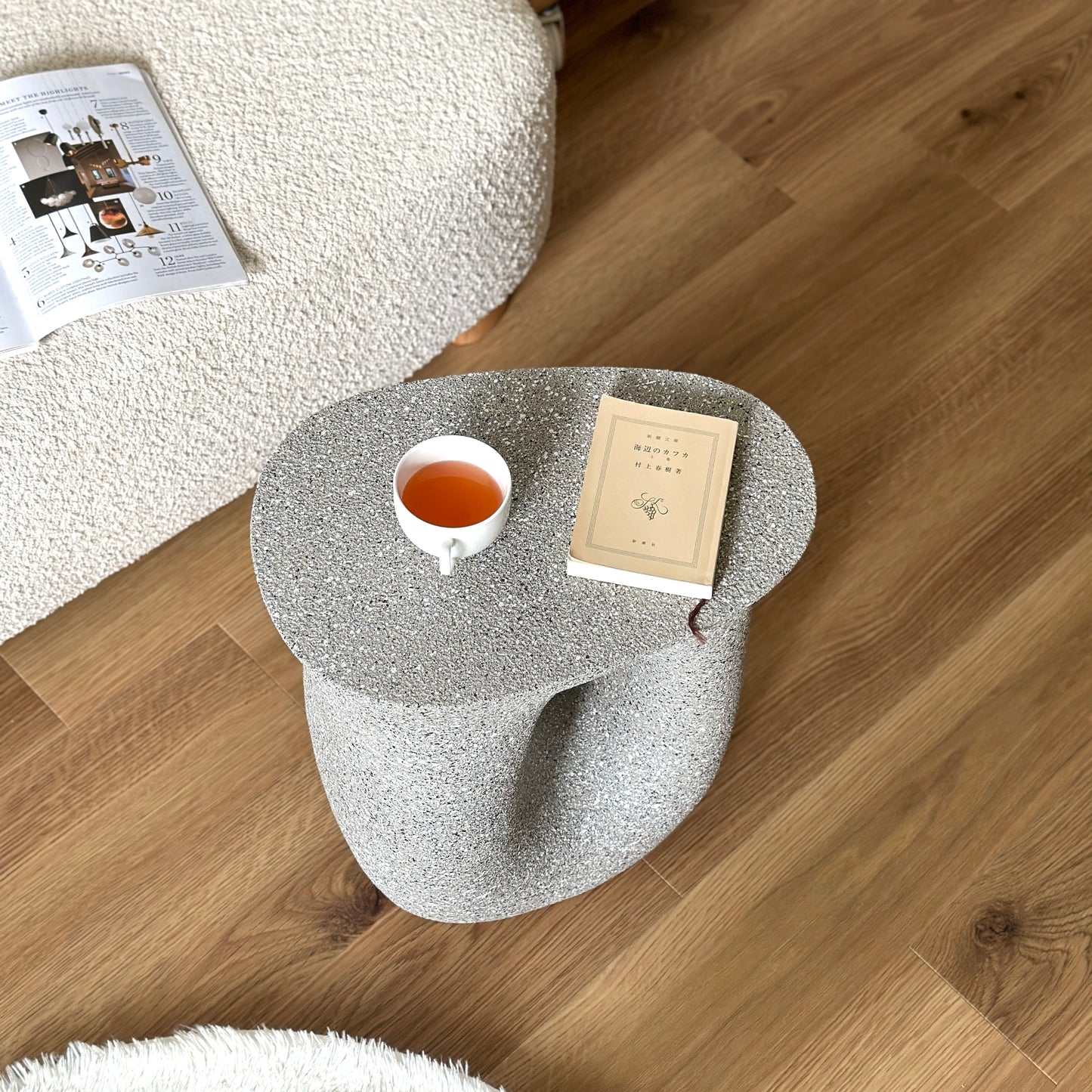 グレーのオブジェのようなミニテーブルがソファサイドに置かれている様子