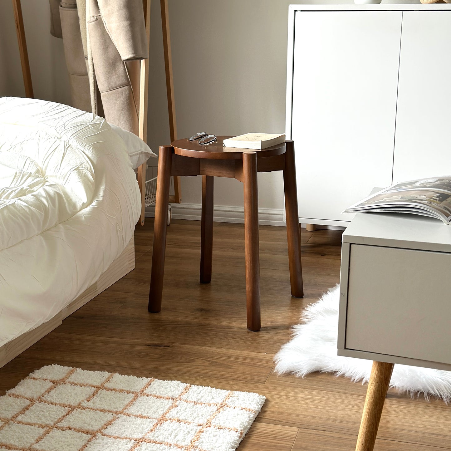 シンプルな木製のスツールの上にメガネと文庫本が置かれてある様子