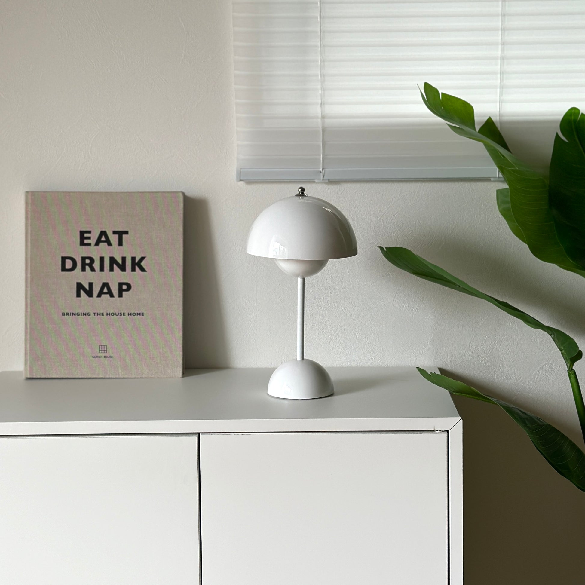 棚の上に乗せられた半球型のシルエットが特徴的なホワイトのテーブルライト