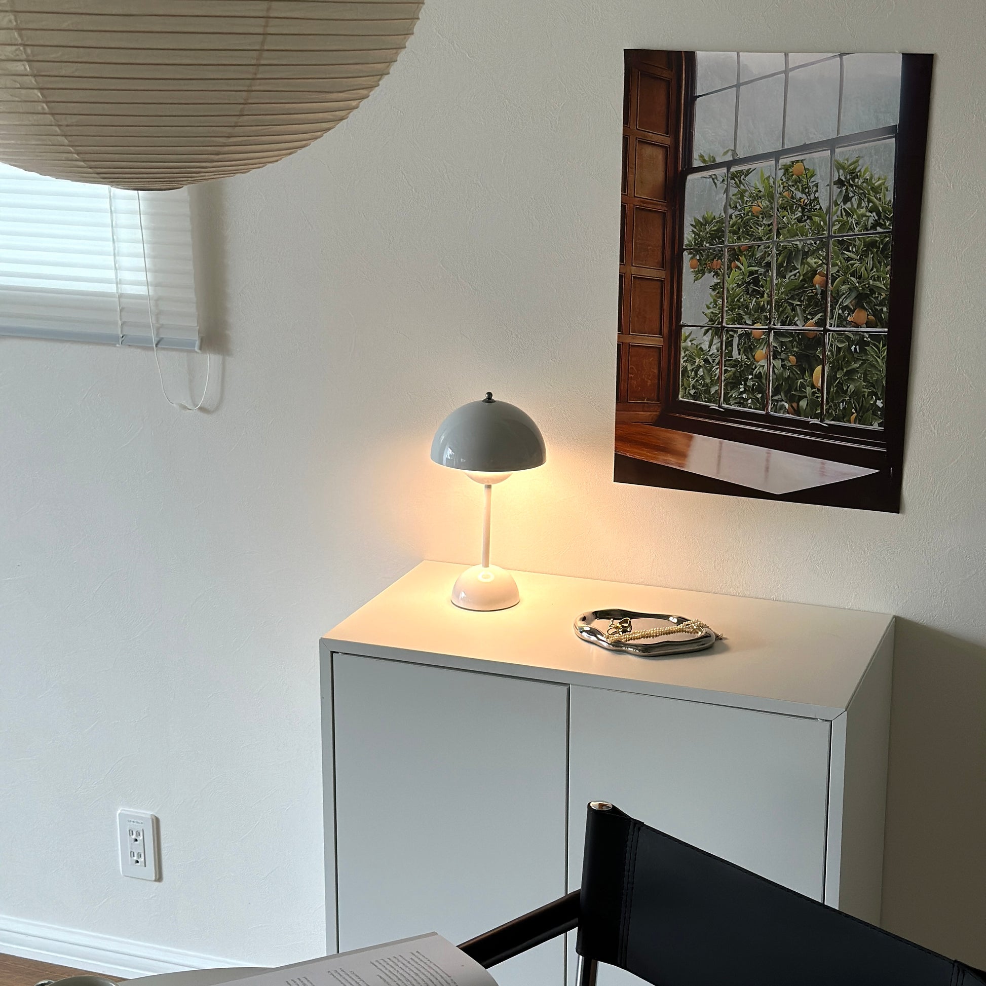 棚の上に乗せられた半球型のシルエットが特徴的なホワイトのテーブルライトとアクセサリー