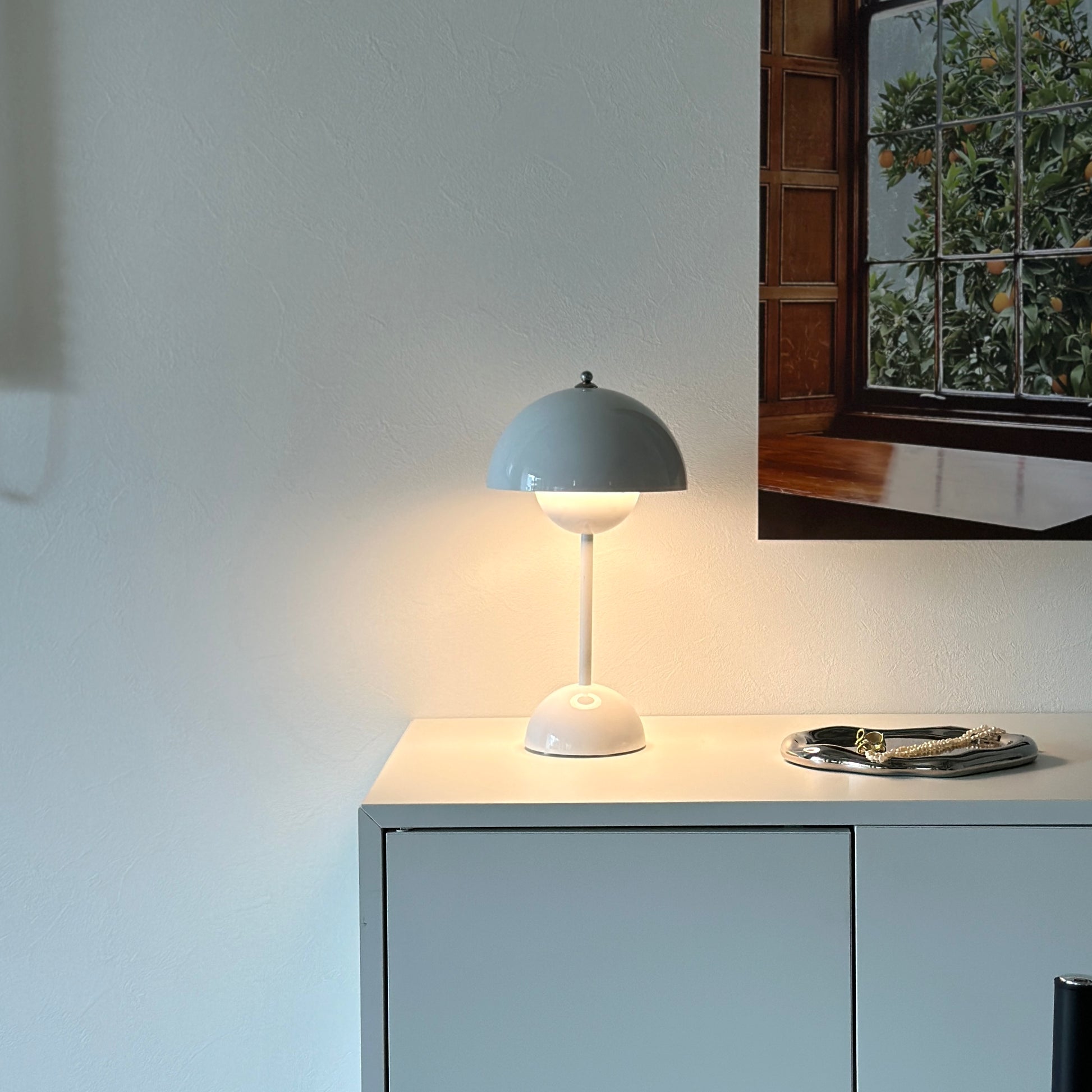 棚の上に乗せられた半球型のシルエットが特徴的なホワイトのテーブルライト