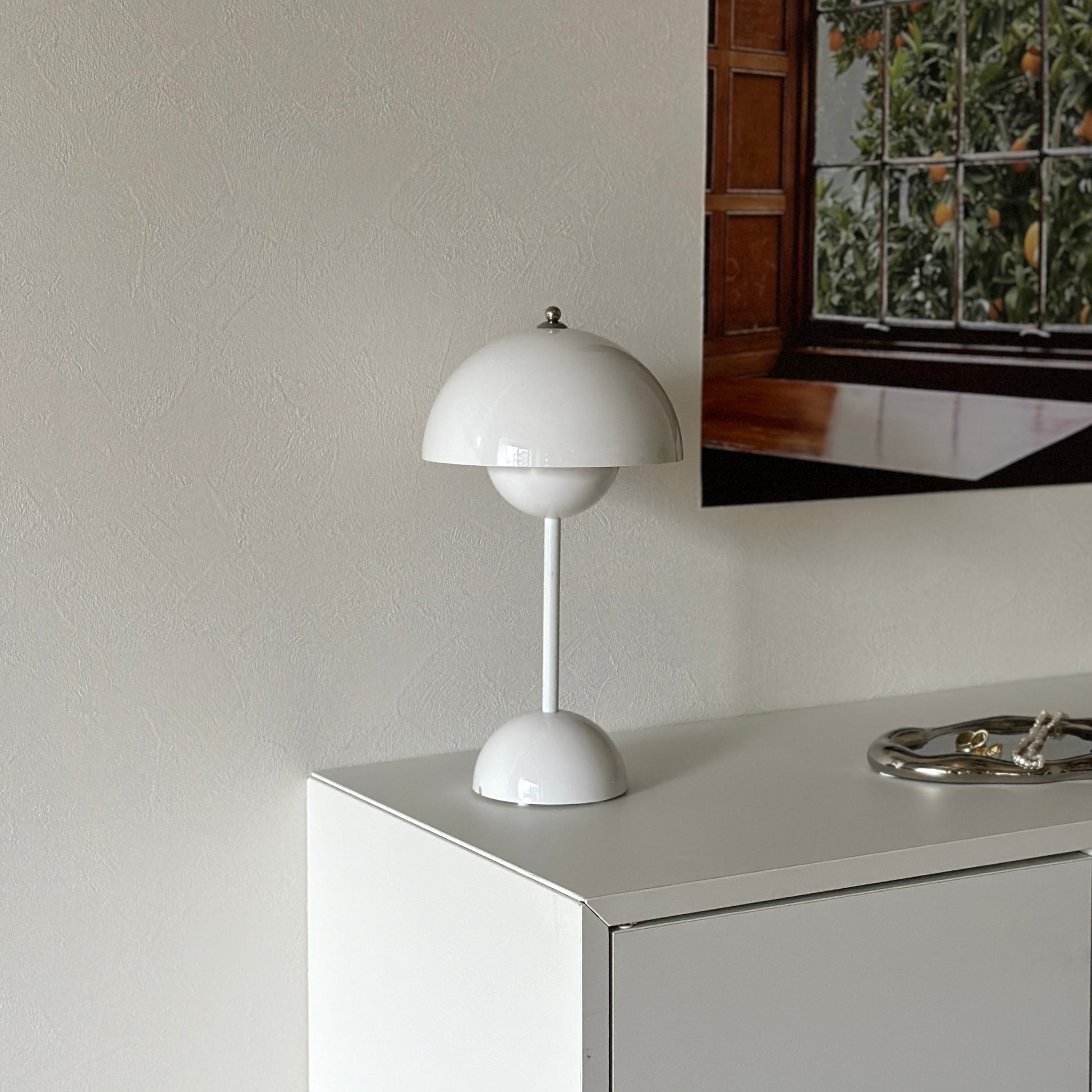 棚の上に乗せられた半球型のシルエットが特徴的なホワイトのテーブルライト