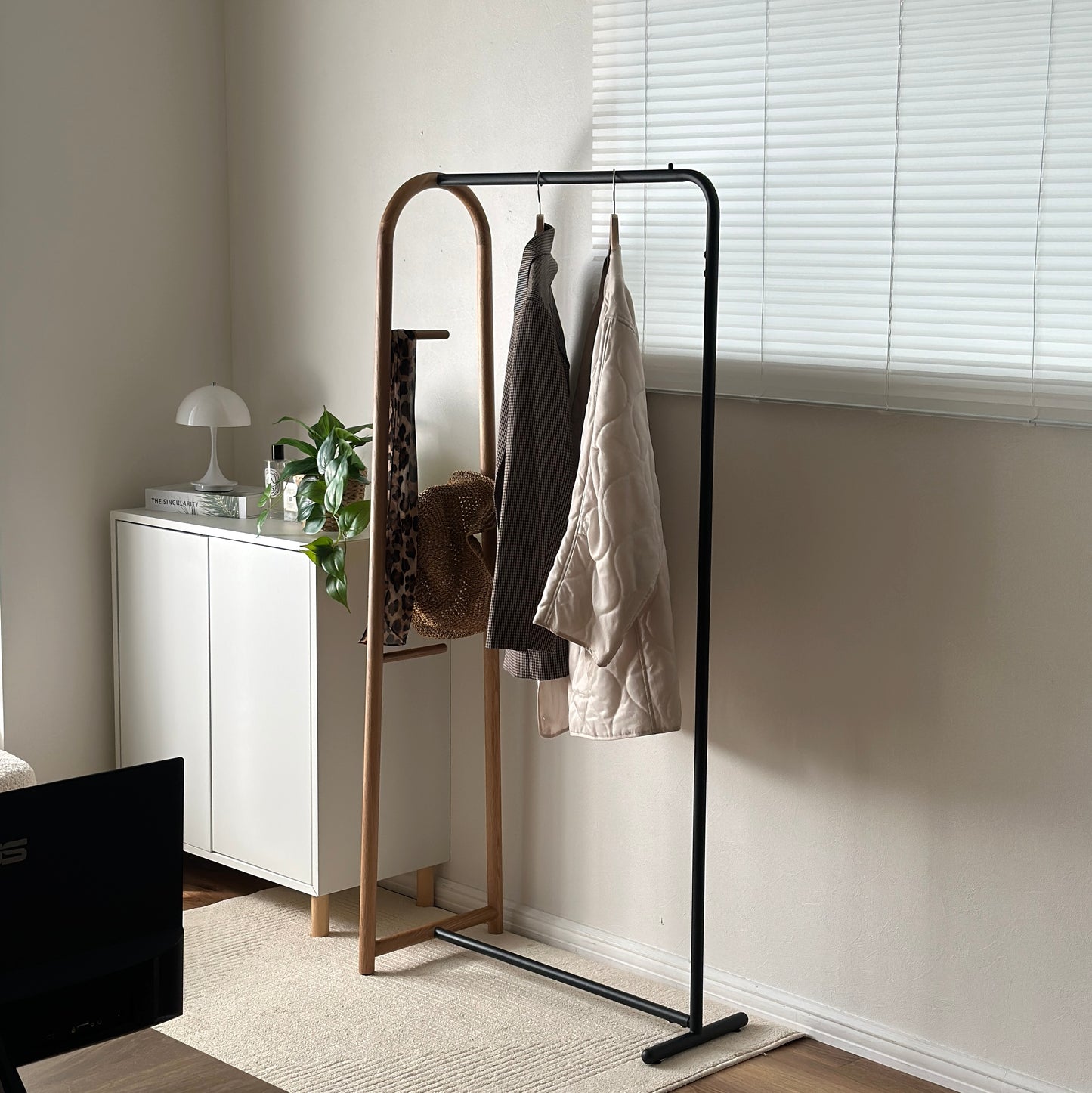 オーク材とブラックスチールのハンガーラックを部屋に置いている様子