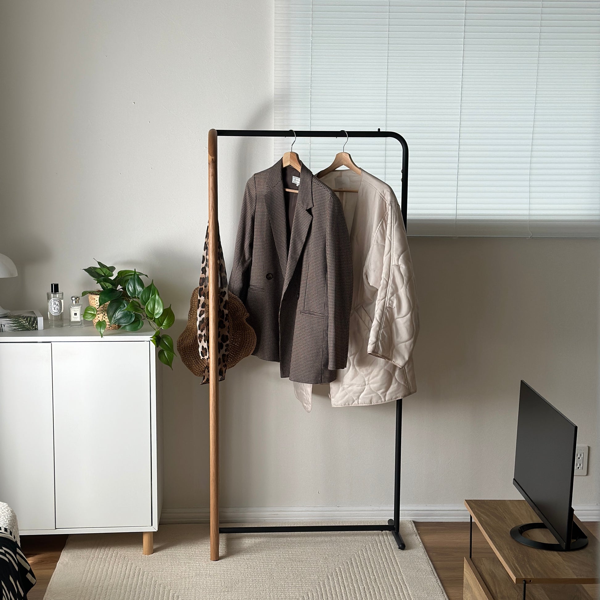 オーク材とブラックスチールのハンガーラックを部屋に置いている様子