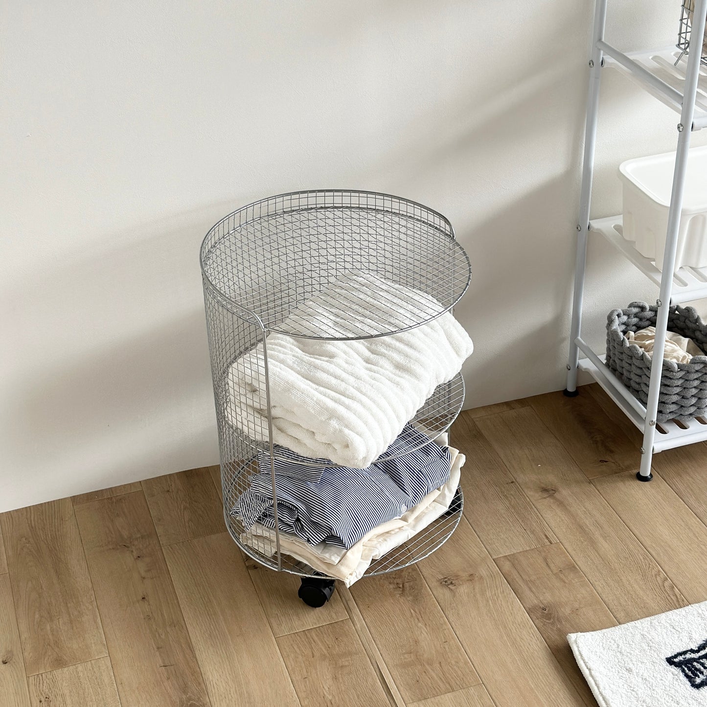 シルバーのメッシュワゴンにタオルや衣類が置かれている様子
