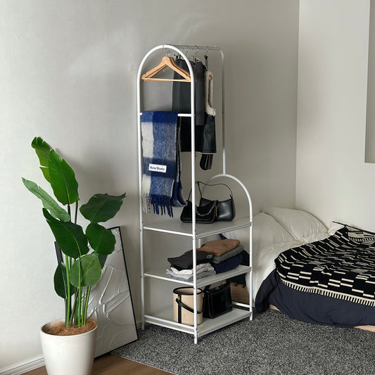 3段棚のハンガーラックをベッド横に置いている様子