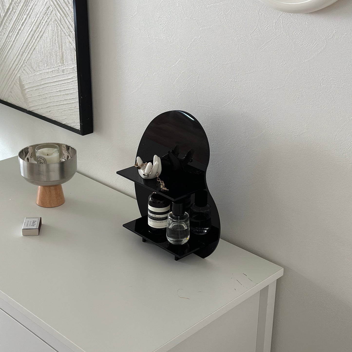 アクリル製の黒のディスプレイラックにアクセサリーや香水が置かれてある