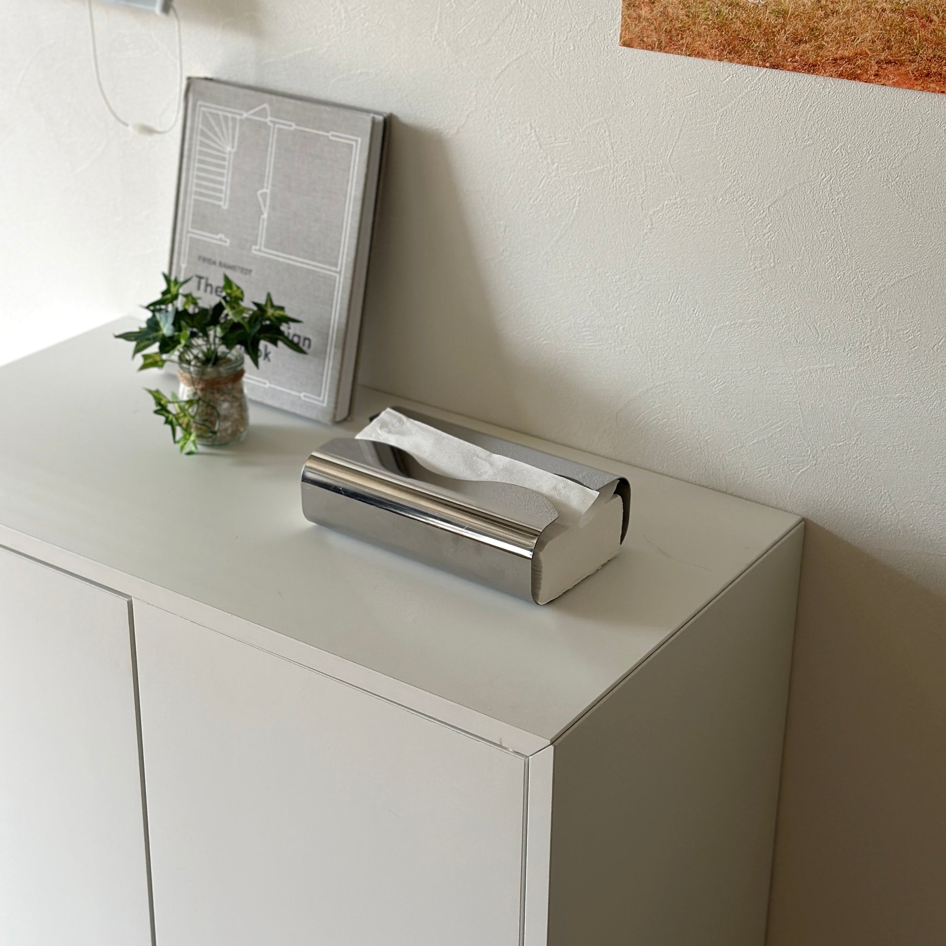 取り出し口がウェーブデザインのステンレス製ティッシュケースが棚の上に置かれている