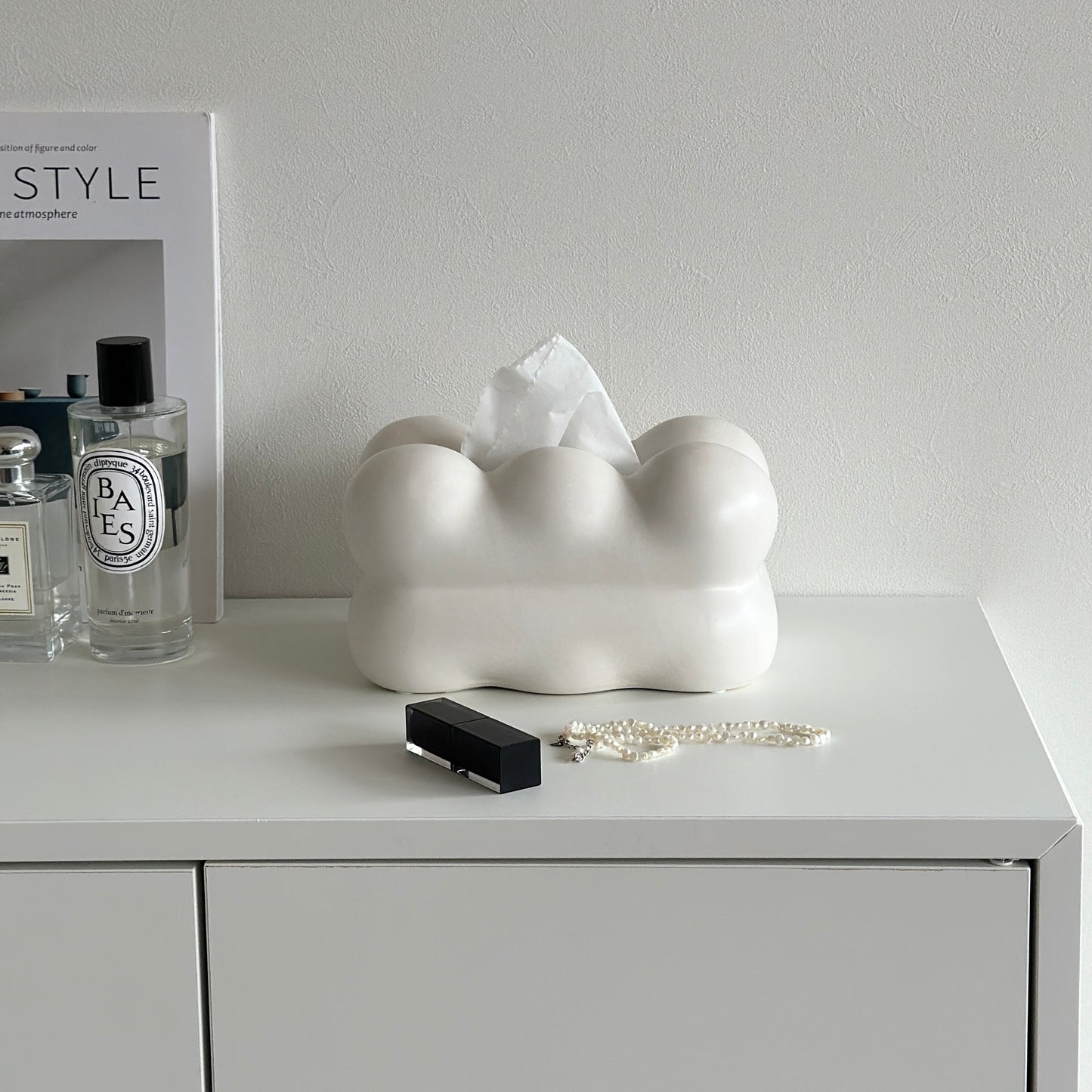 もくもくしたセラミック製の白いティッシュケースがホワイトのシェルフの上にアクセサリーなどと一緒に置かれている様子