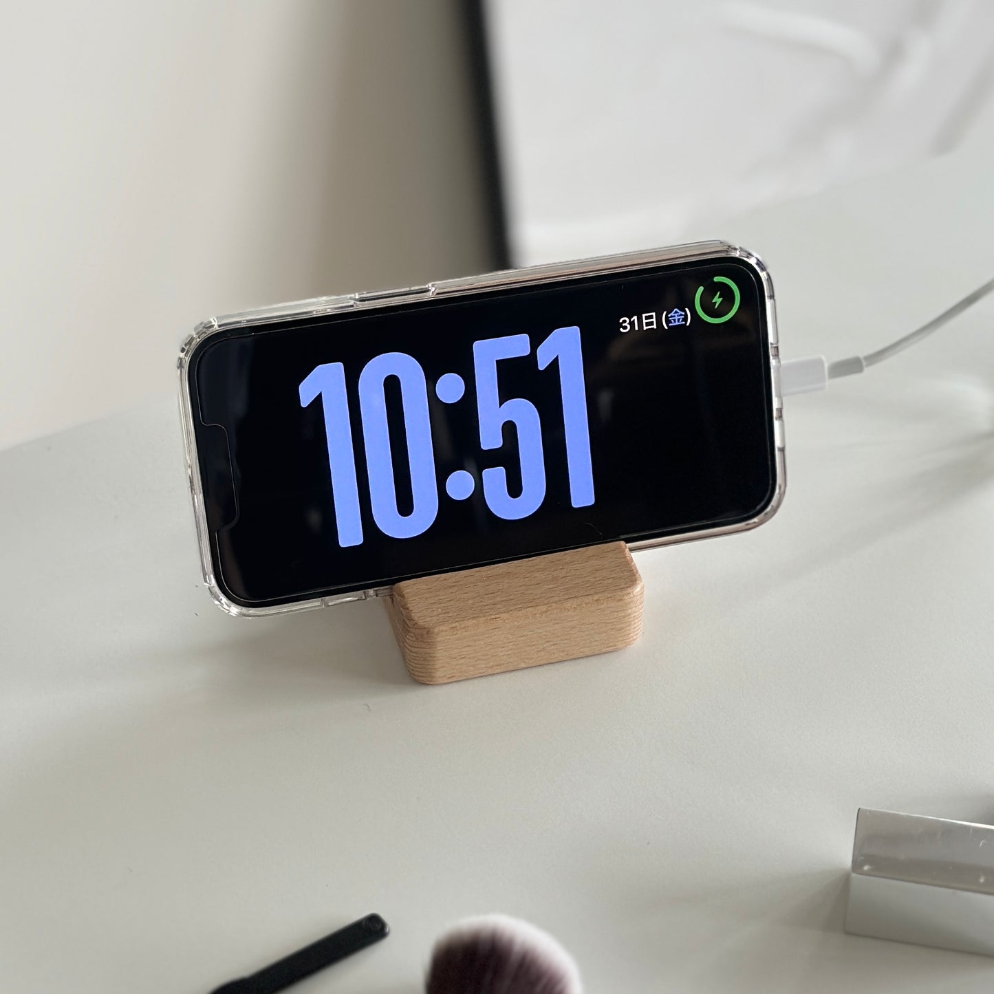 木製のスマホスタンドにスマホを立てている様子