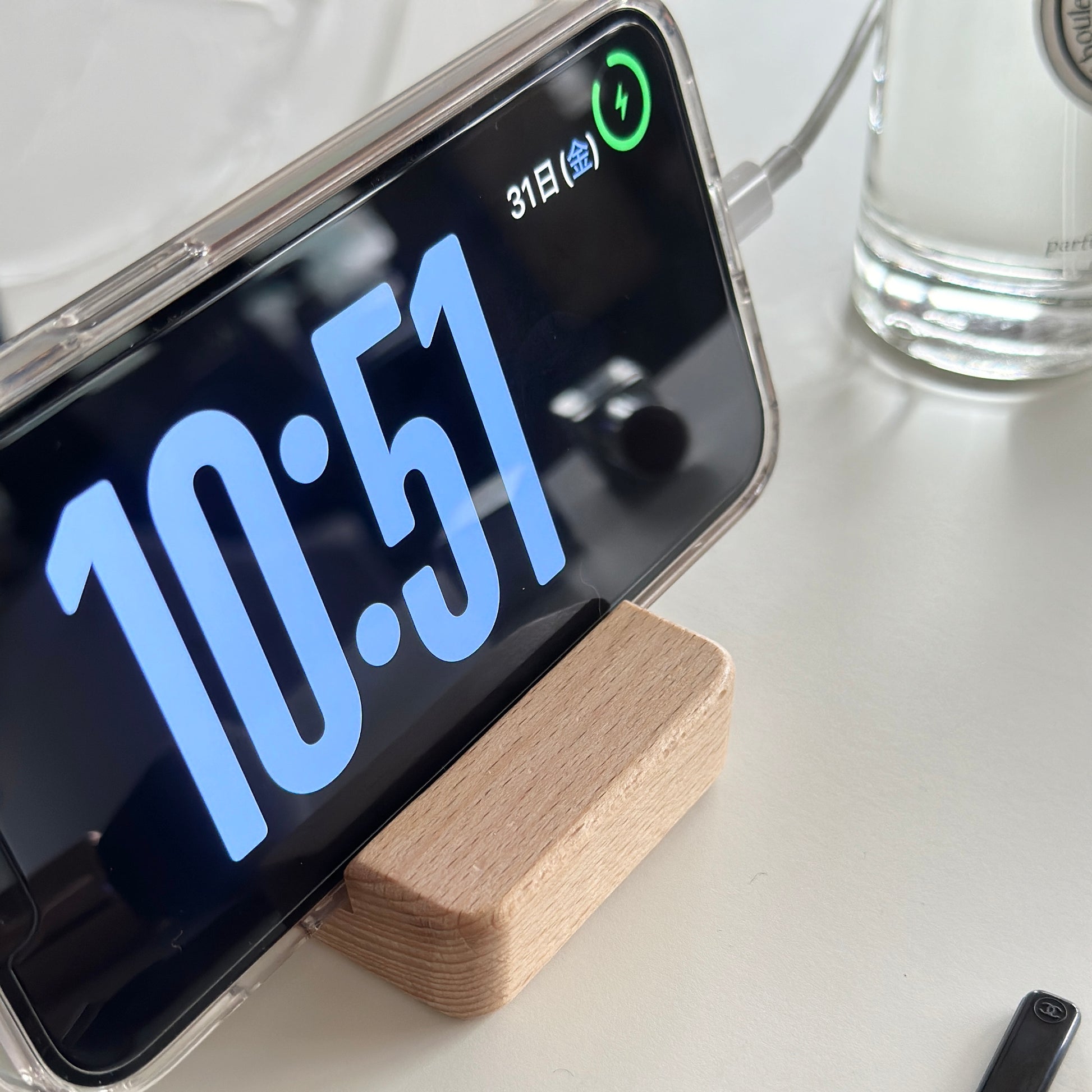 木製のスマホスタンドにスマホを立てている様子