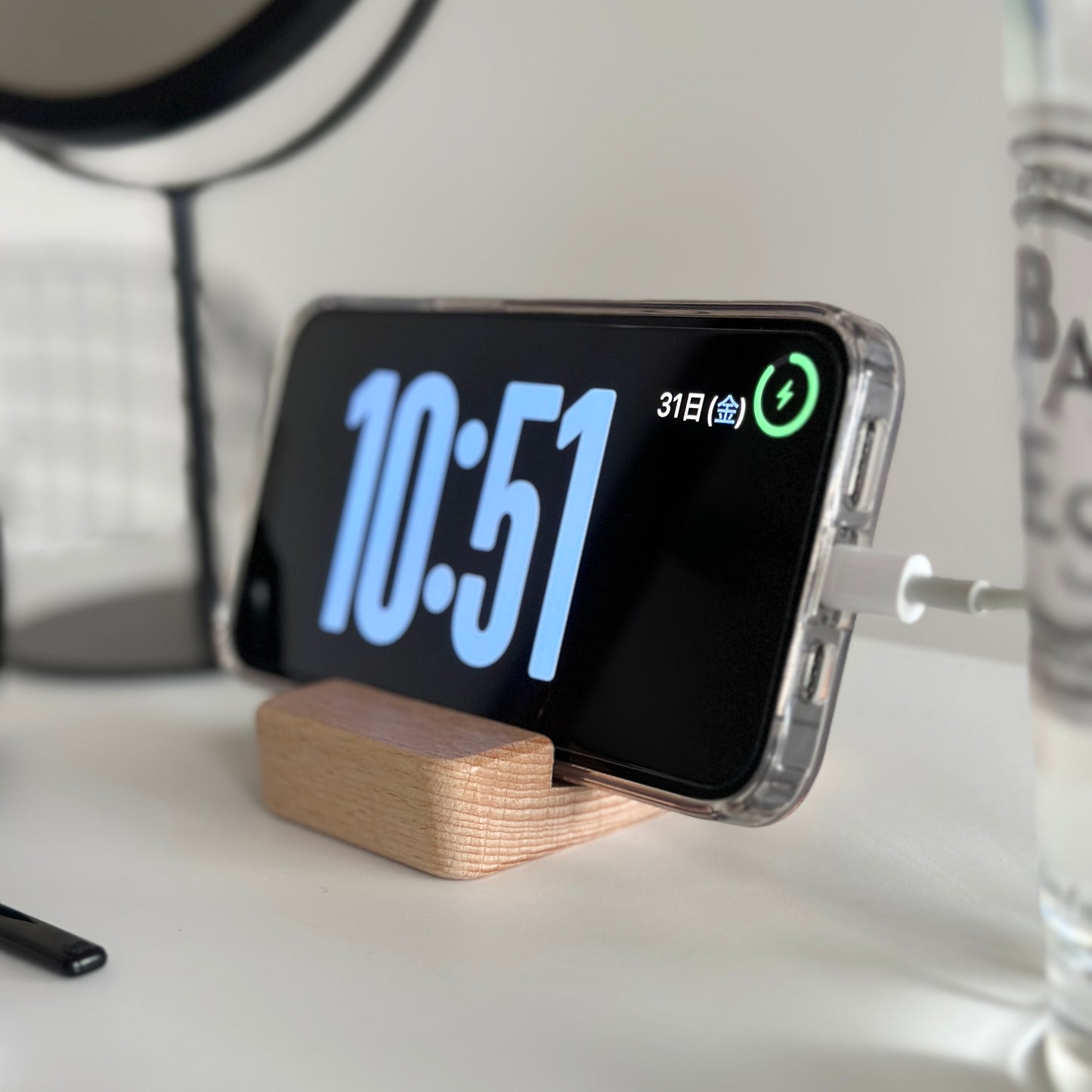 木製のスマホスタンドにスマホを立てている様子