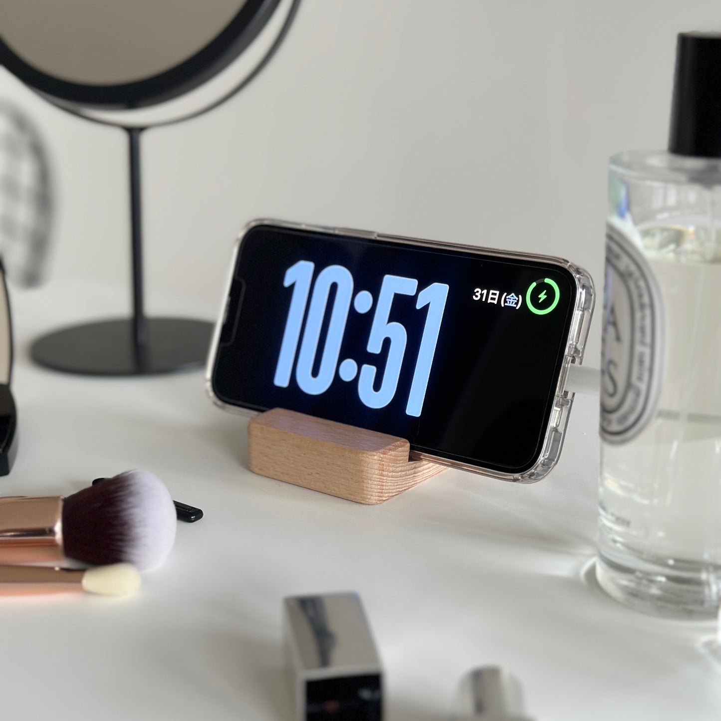 木製のスマホスタンドにスマホを立てている様子