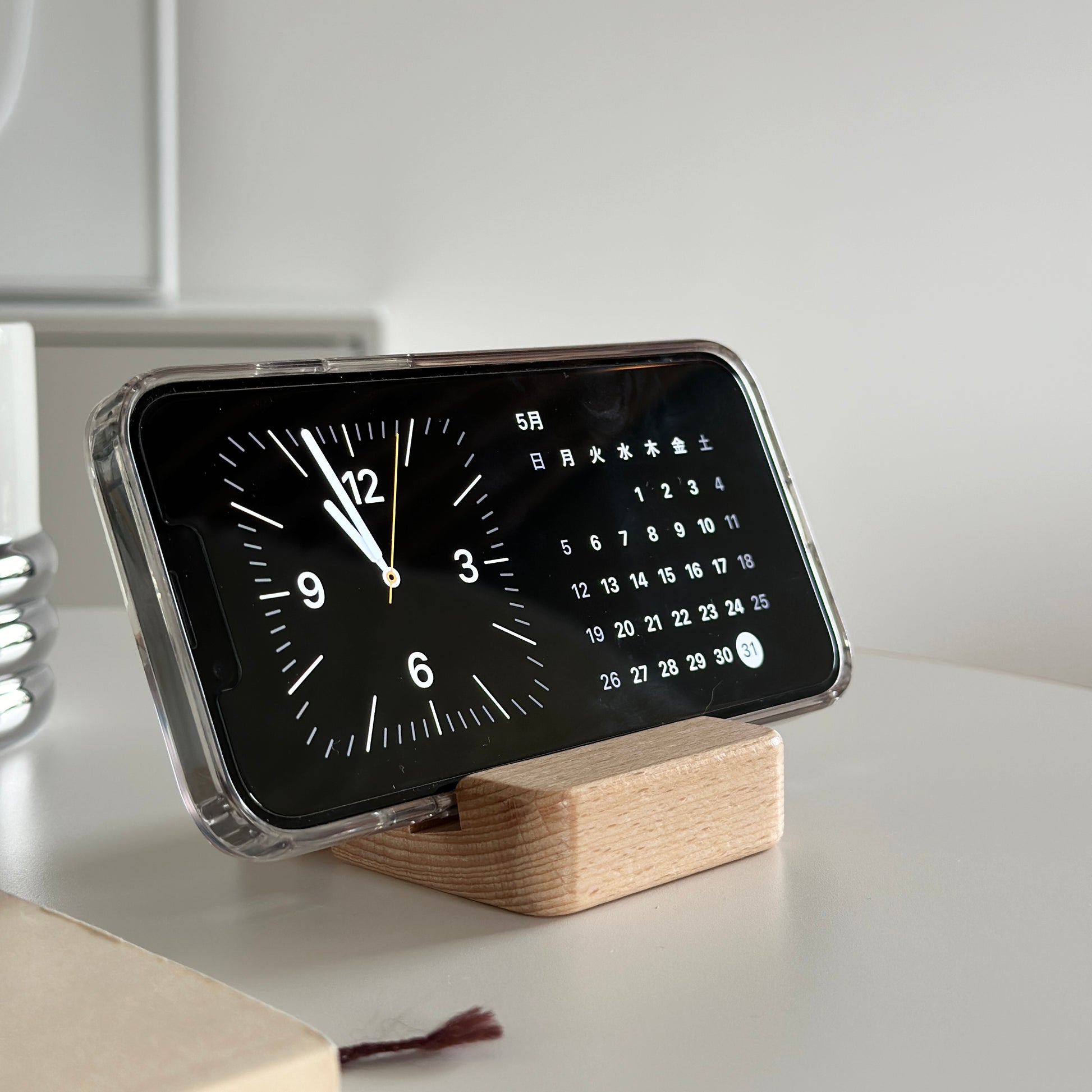 木製のスマホスタンドにスマホを立てている様子