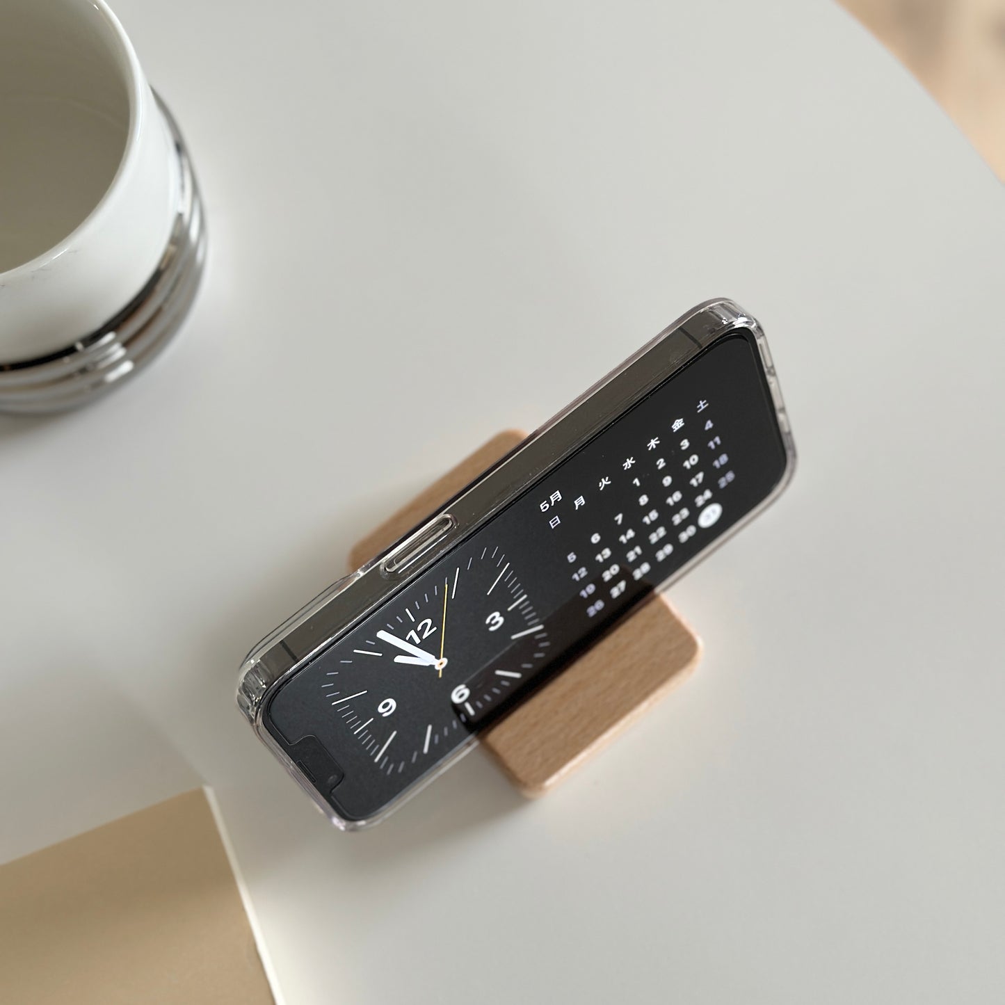 木製のスマホスタンドにスマホを立てている様子